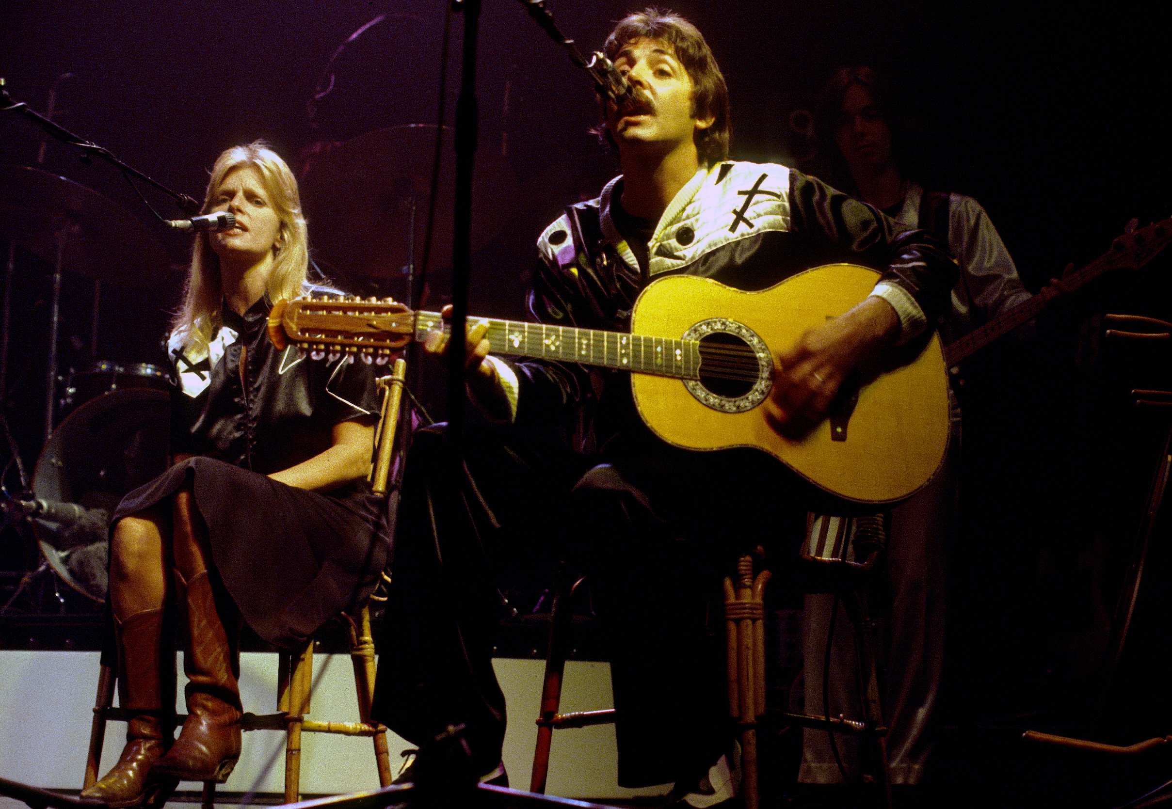 Paul McCartney with his wife Linda Eastman perform on stage on October 01, 1976 in London, England | Source: Getty Images
