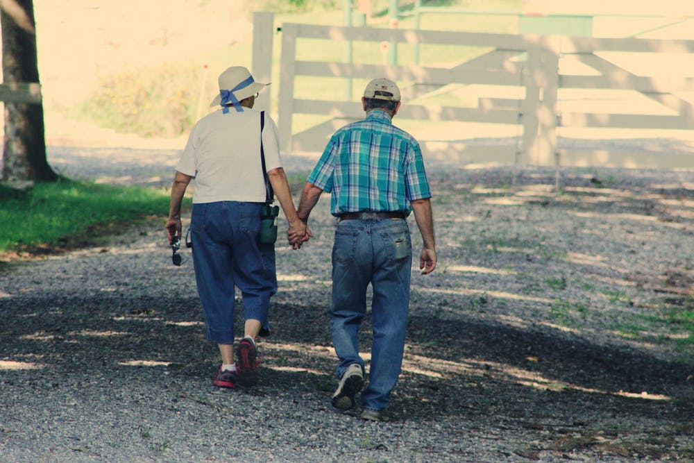Pareja de ancianos caminando mientras cogidos de la mano. |  Foto: Pexels