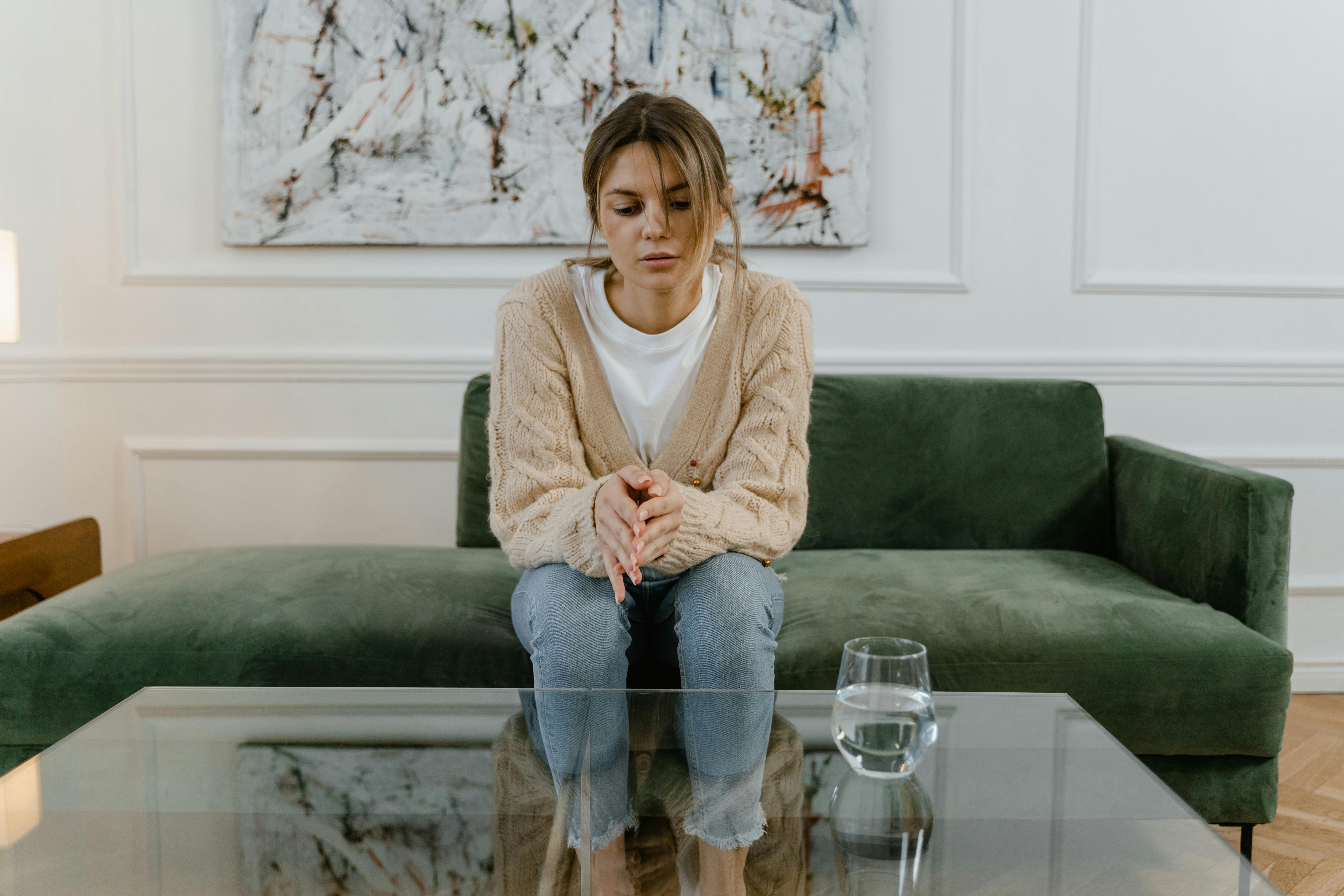 Embarrassed woman sitting on the sofa | Source: Pexels