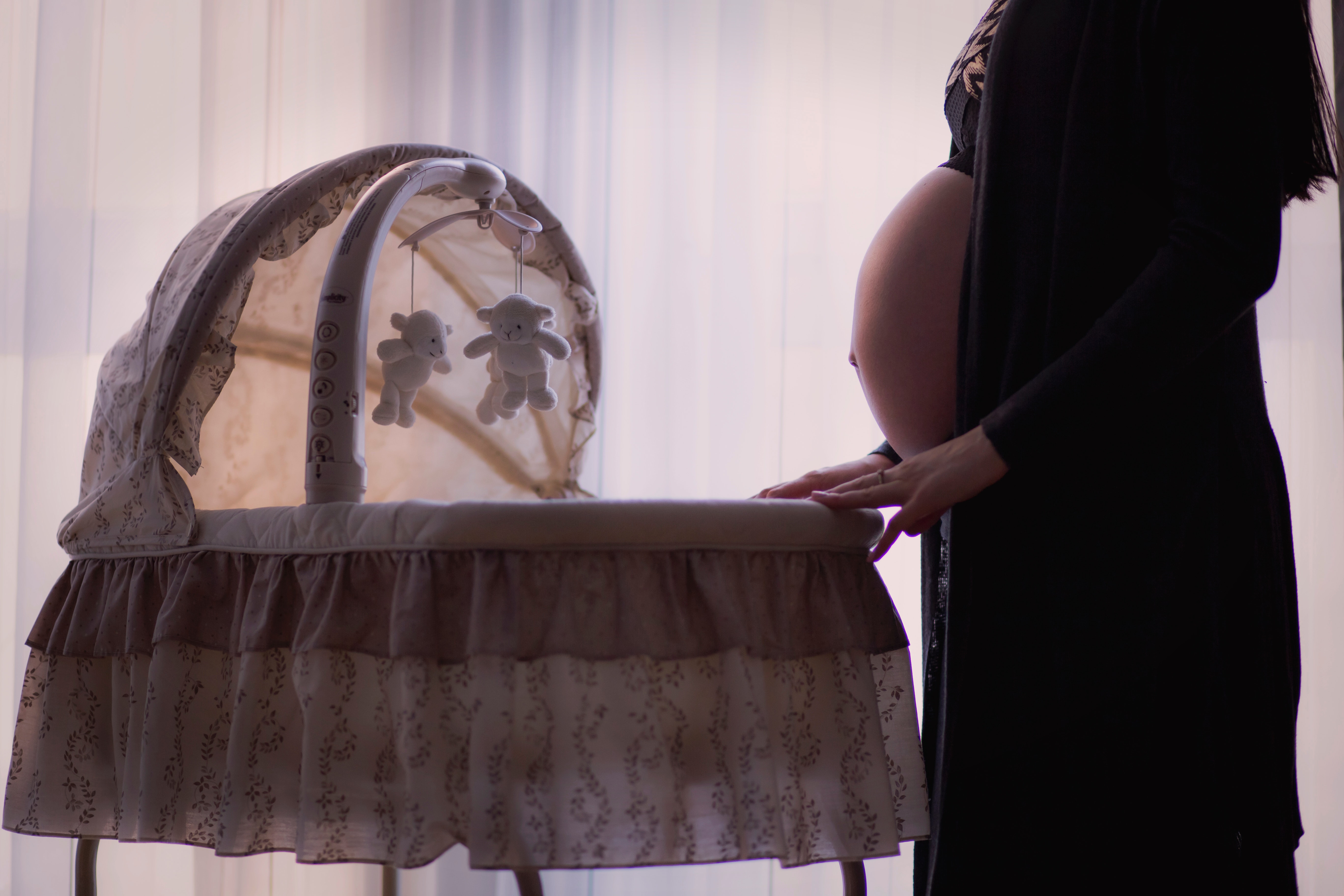 Pregnant woman standing near a bassinet | Source: Pexels