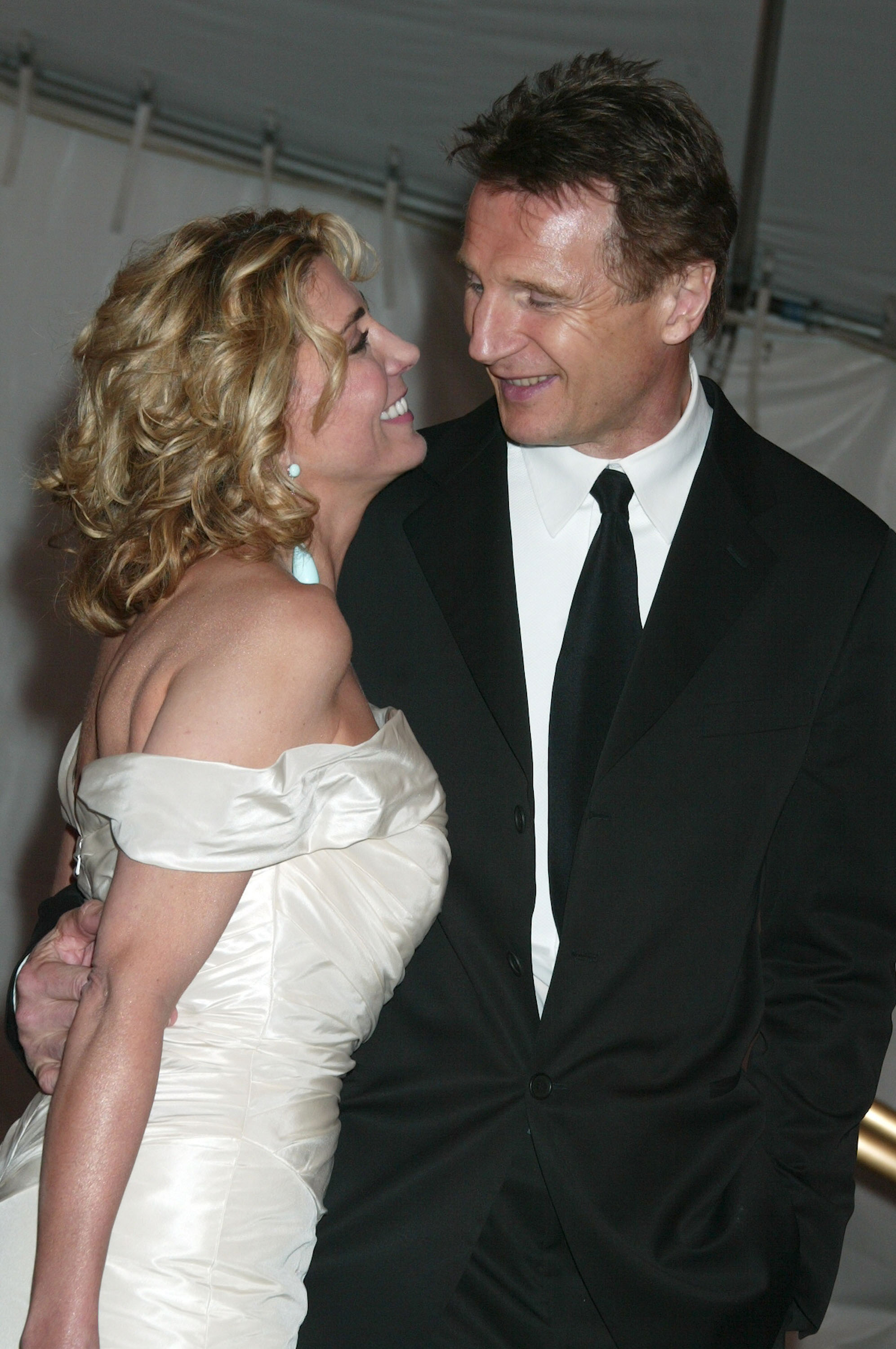 Natasha Richardson and Liam Neeson share a tender look while departing the Costume Institute Gala Celebrating “Chanel” at the Metropolitan Museum of Art in New York City on May 2, 2005. They stand close together, smiling as they leave the high-profile event.