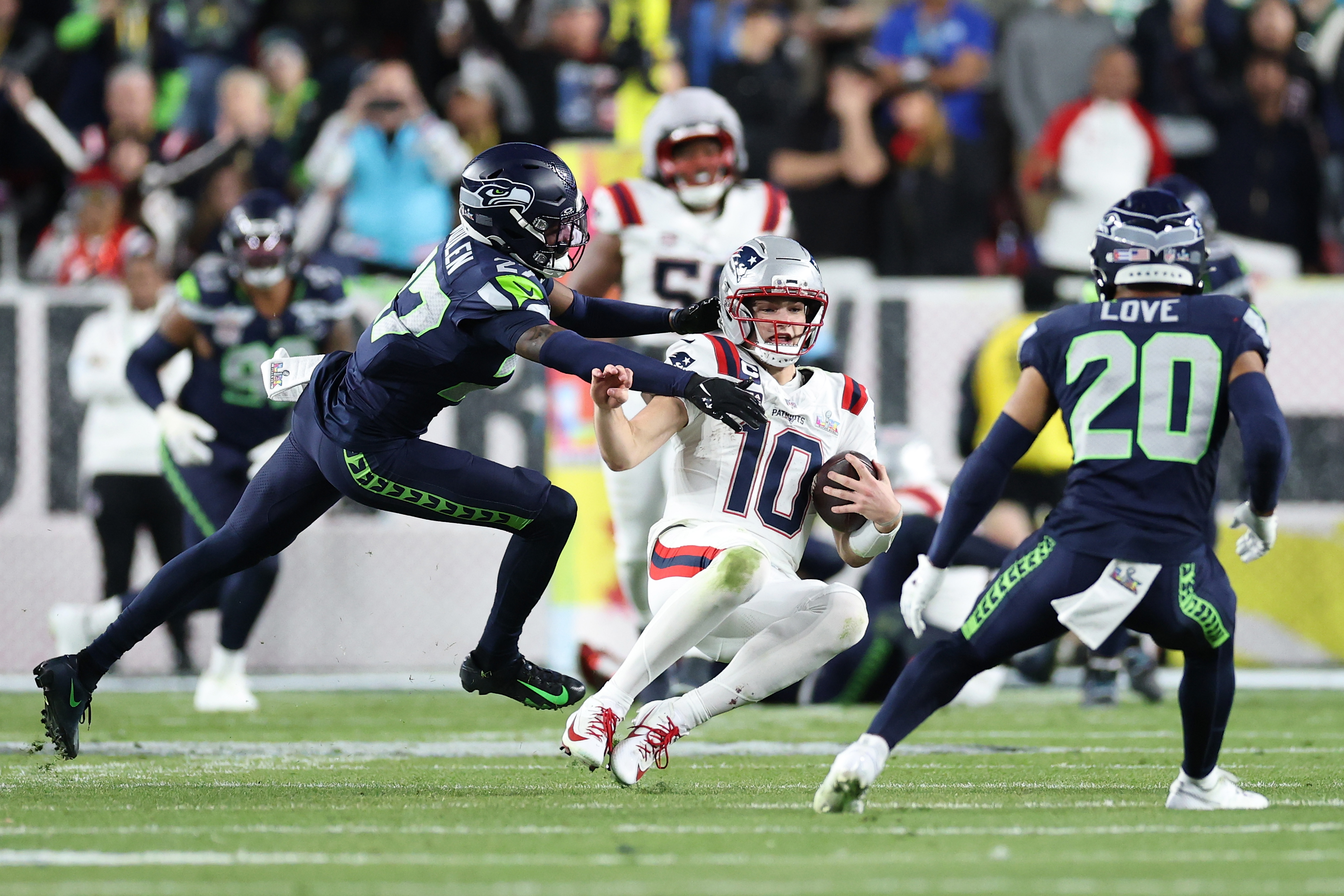 New England Patriots quarterback Drake Maye is pressured by Seattle Seahawks defenders Riq Woolen and Julian Love during Super Bowl LX on February 8, 2026 | Source: Getty Images