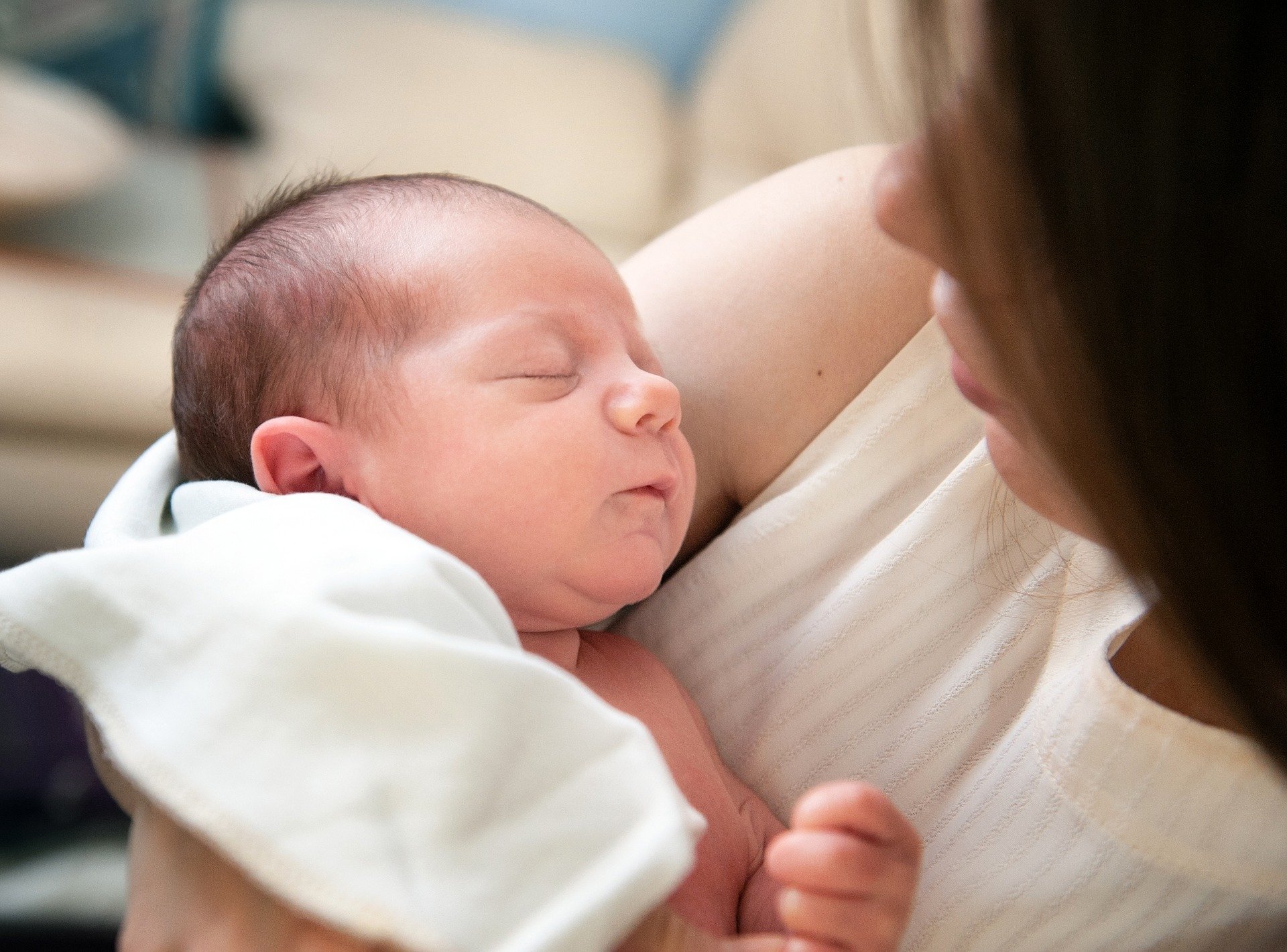 Mother gazing at her sleeping newborn in her arms. | Source: Iuliia Bondarenko/Pixabay