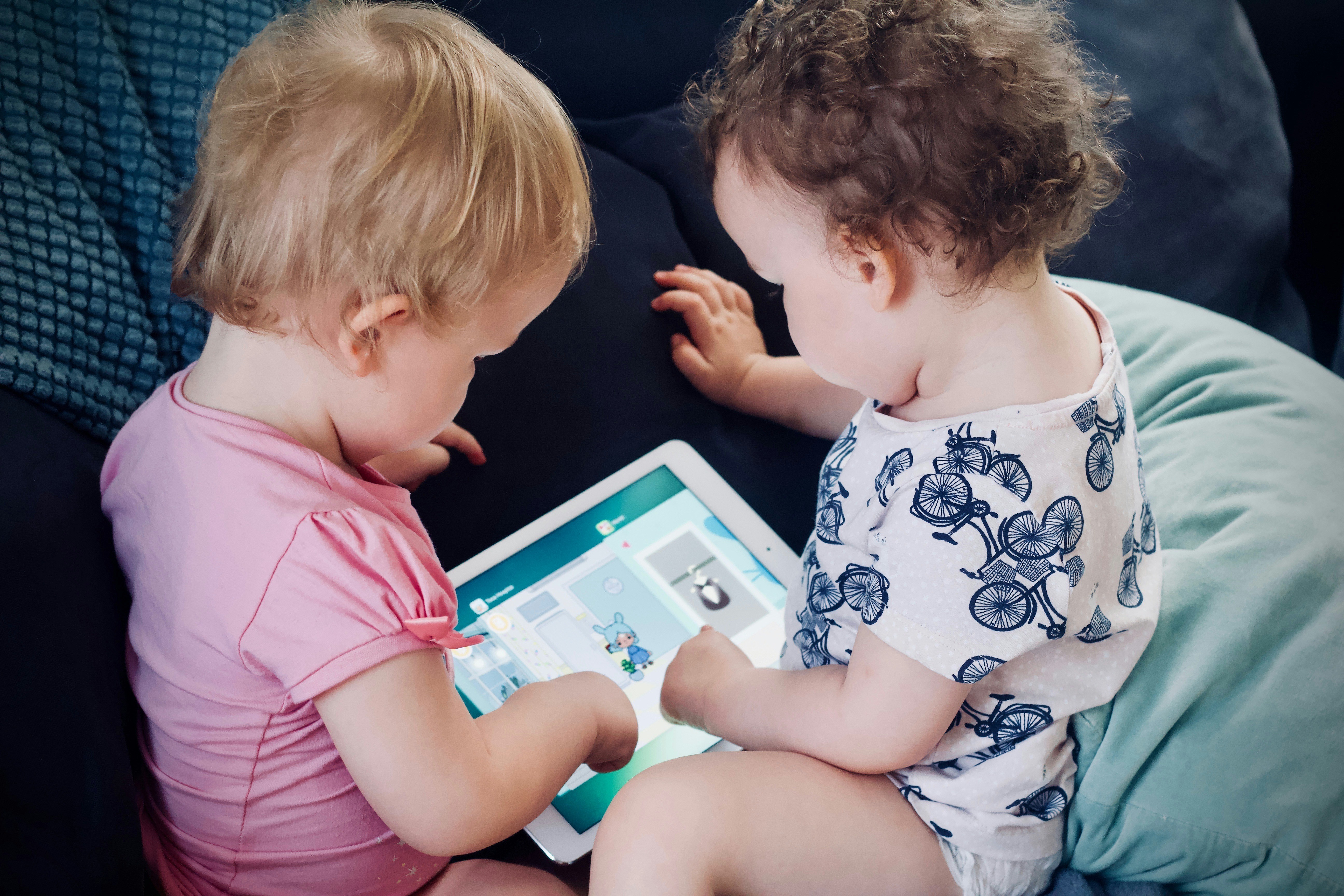 Two kids busy on their tab | Source: Unsplash