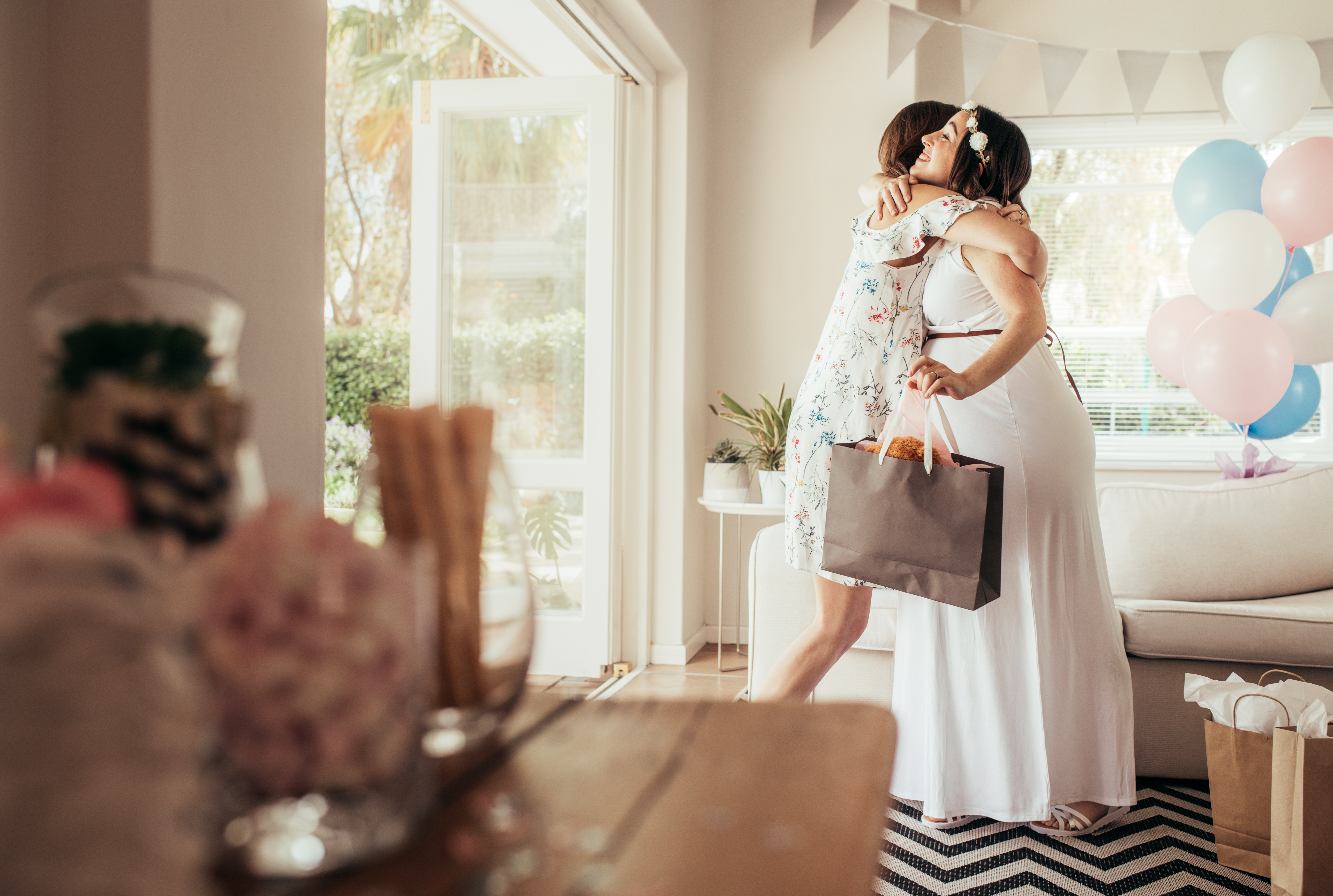 Woman hugging expecting mother at baby shower | Source: Shutterstock