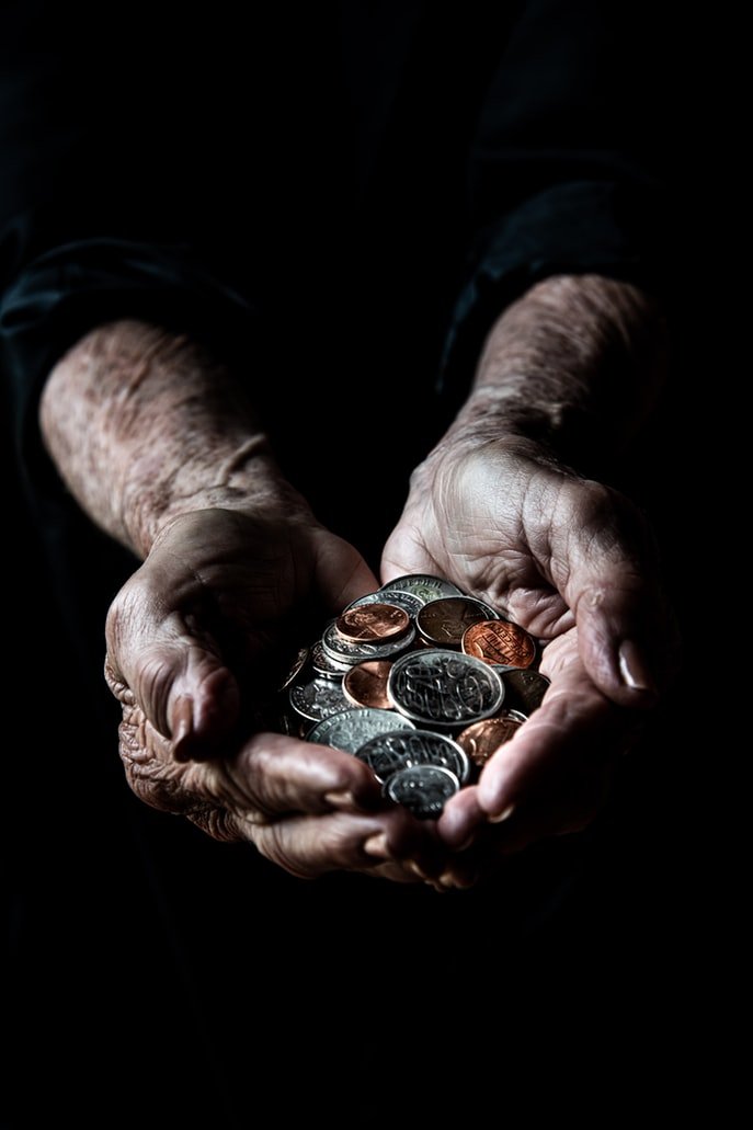 Manos ancianas con monedas. | Foto: Unsplash
