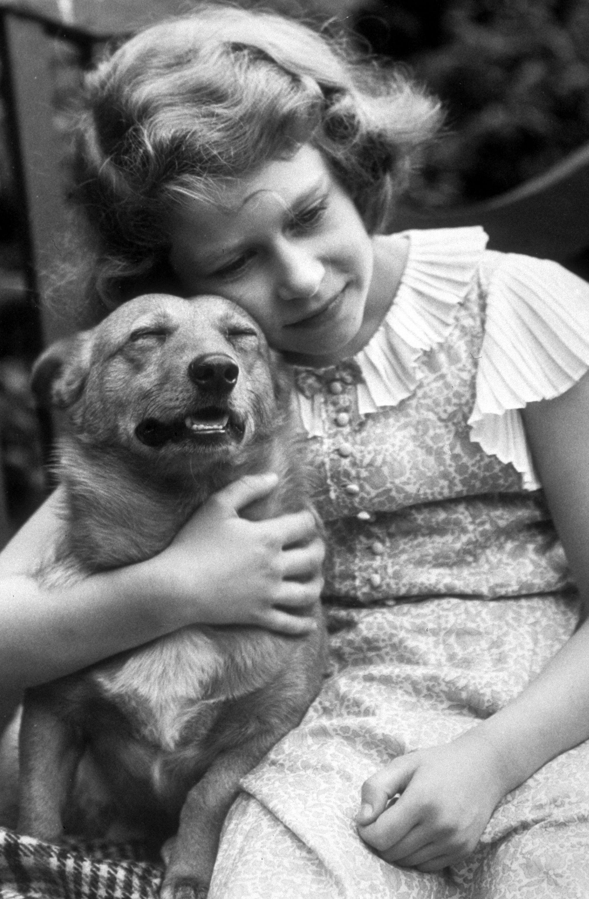 Prinzessin Elizabeth stellte sich im Juli 1936 vor, wie sie einen Corgi umarmte. | Quelle: Getty Images