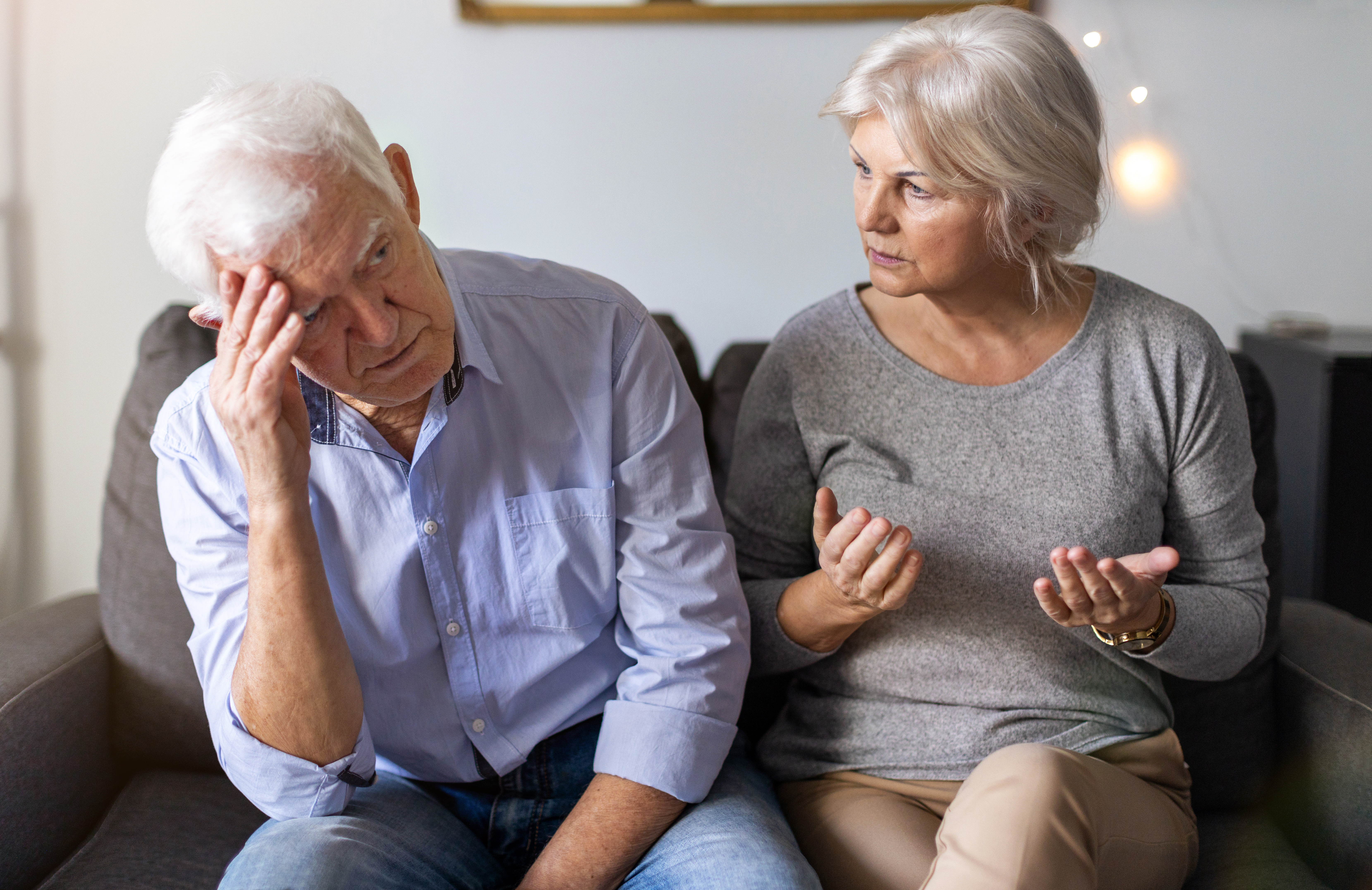 A man and a woman sitting on a couch | Source: Shutterstock