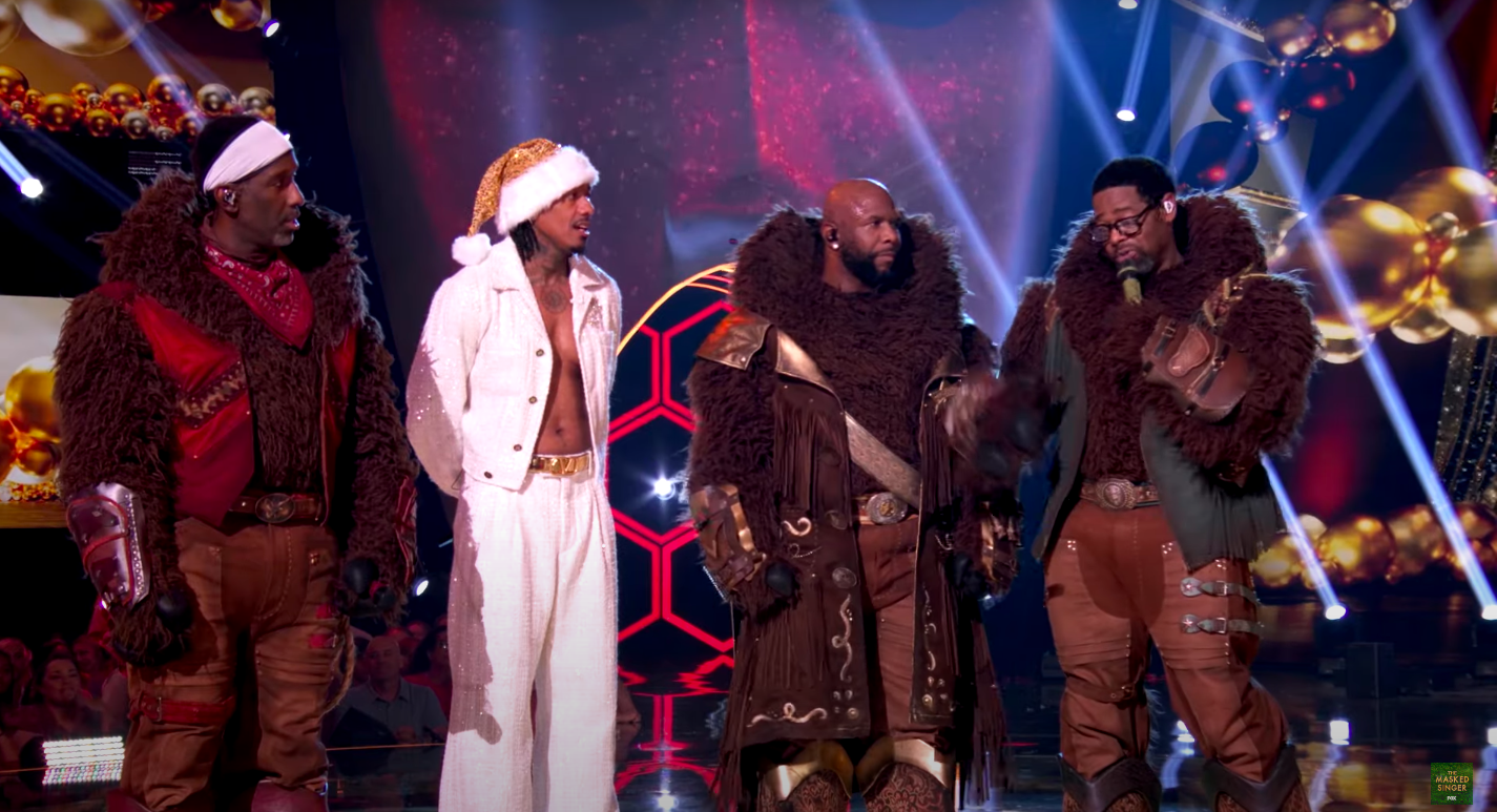 Nathan Morris continuing to speak as Wanya Morris, Shawn Stockman, and Nick Cannon looked on. | Source: YouTube/The Masked Singer