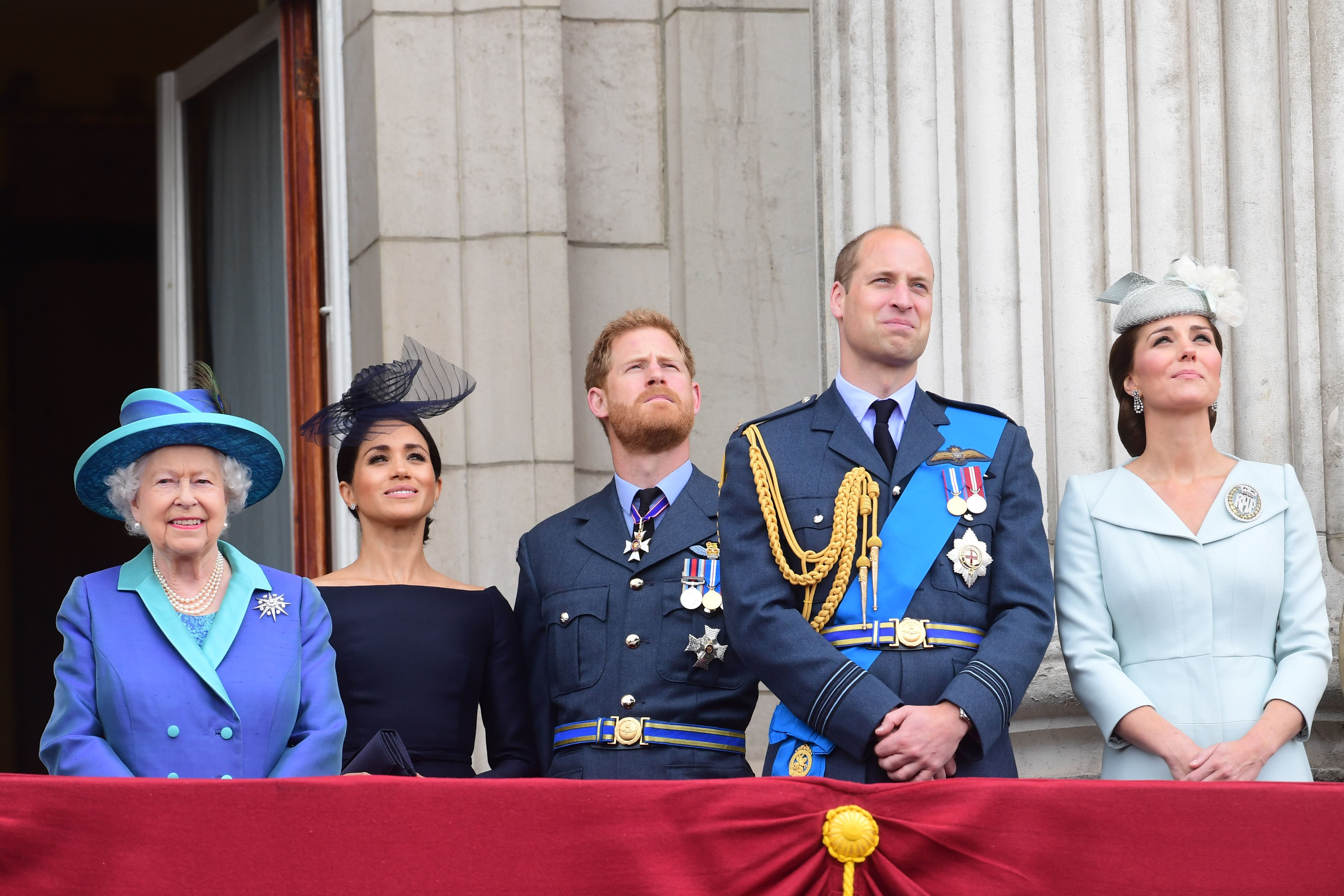 Queen Elizabeth II, Meghan, Duchess of Sussex, Prince Harry, Duke of Sussex, Prince William Duke of Cambridge and Catherine, Duchess of Cambridge captured watching the RAF 100th anniversary flypast from the balcony of Buckingham Palace on July 10, 2018 in London, England. / Source: Getty Images