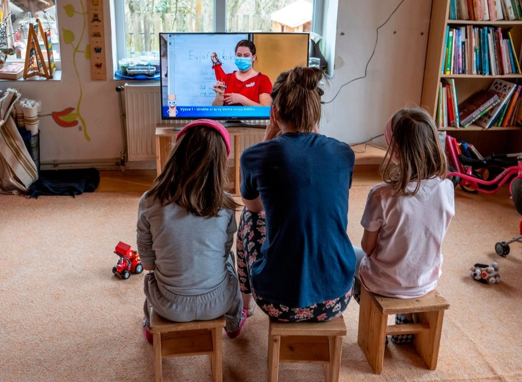 Une femme et ses deux filles devant la télévision. ǀ Source : Getty Images