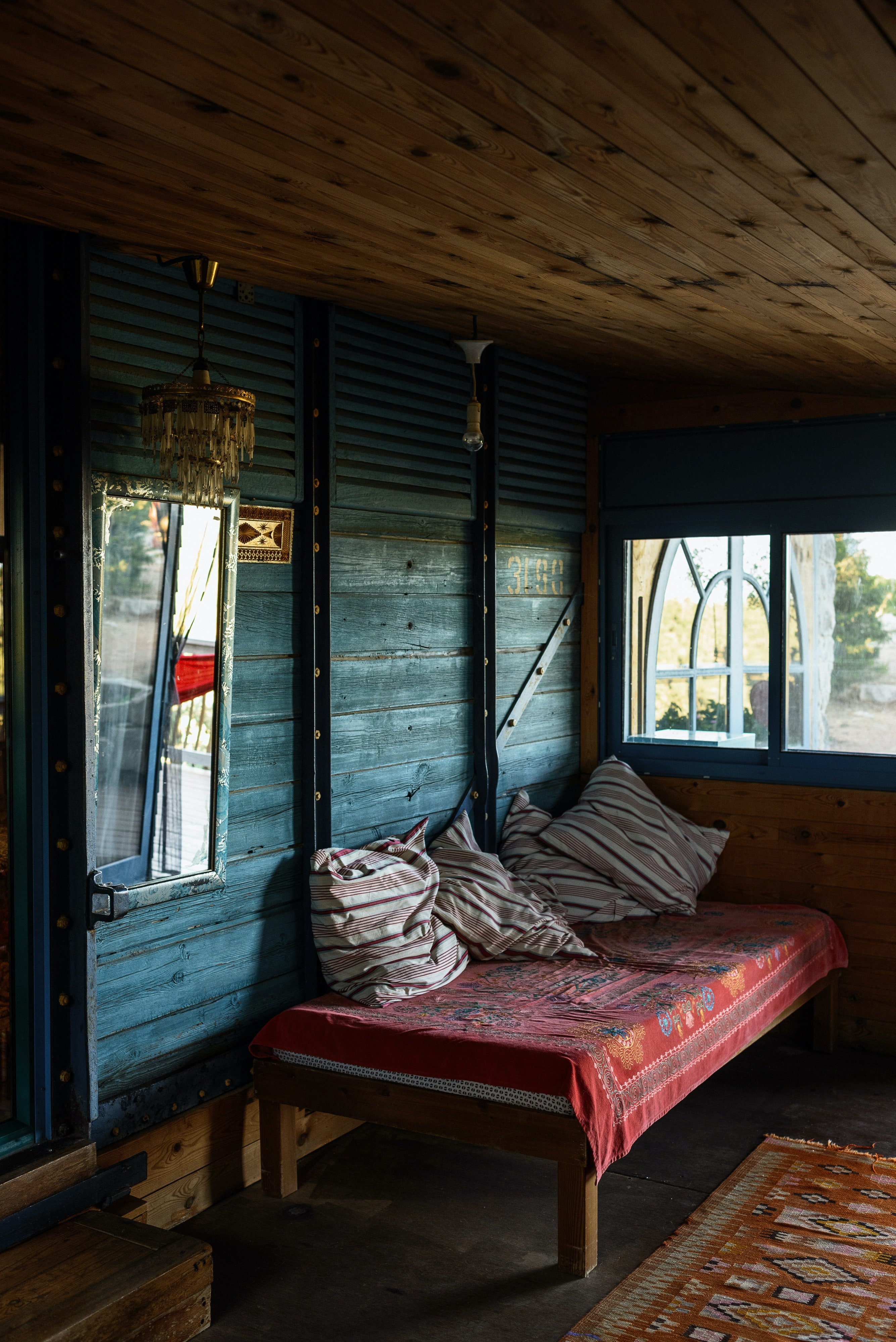 Parte interior de una antigua casa de madera con una pequeña cama. | Foto: Pexels