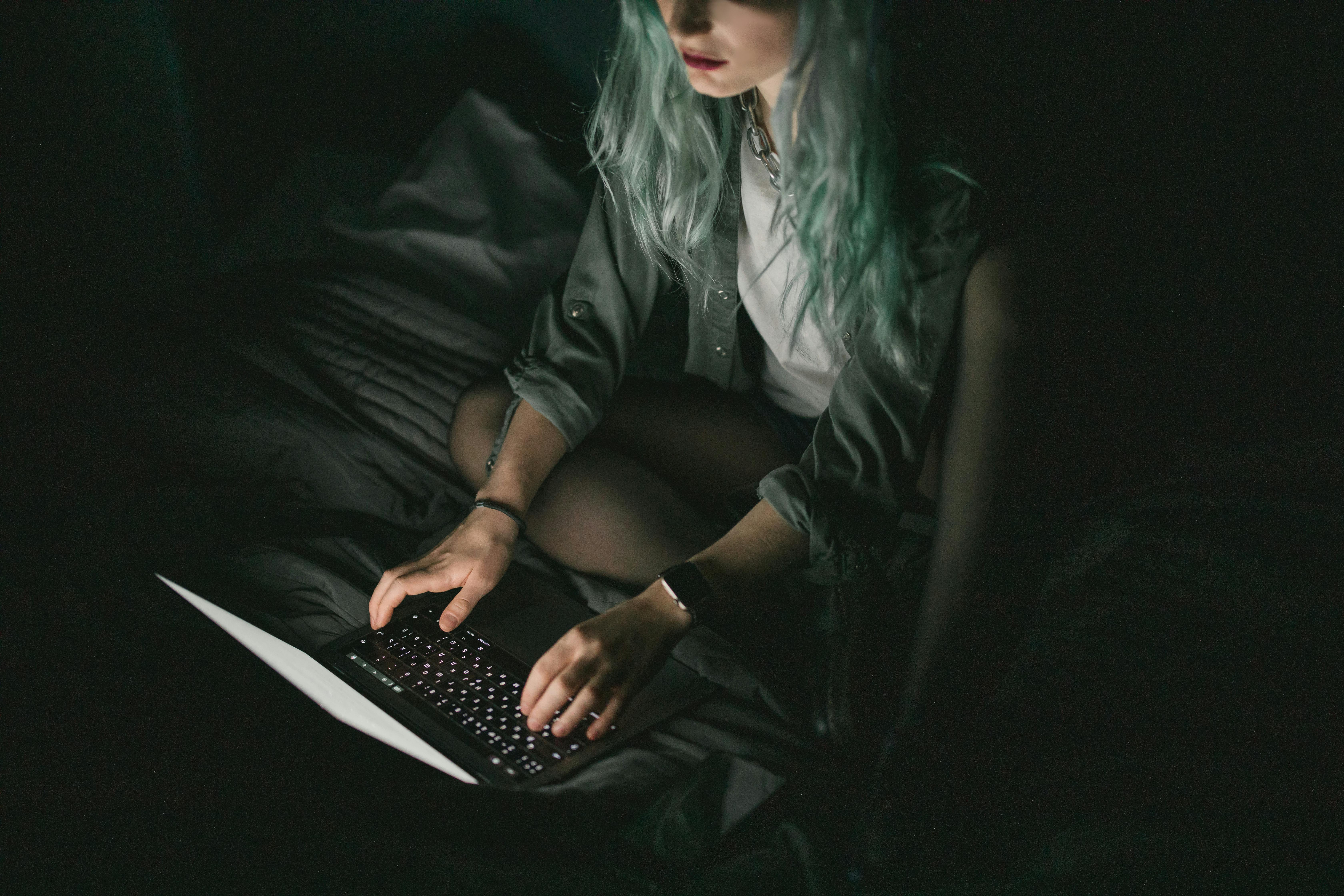 A woman using her laptop at night | Source: Pexels