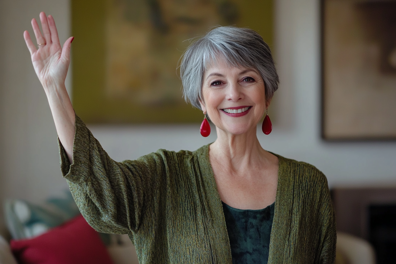 Uma mulher na casa dos 60 anos acena em despedida com um sorriso na sala de estar | Fonte: Midjourney