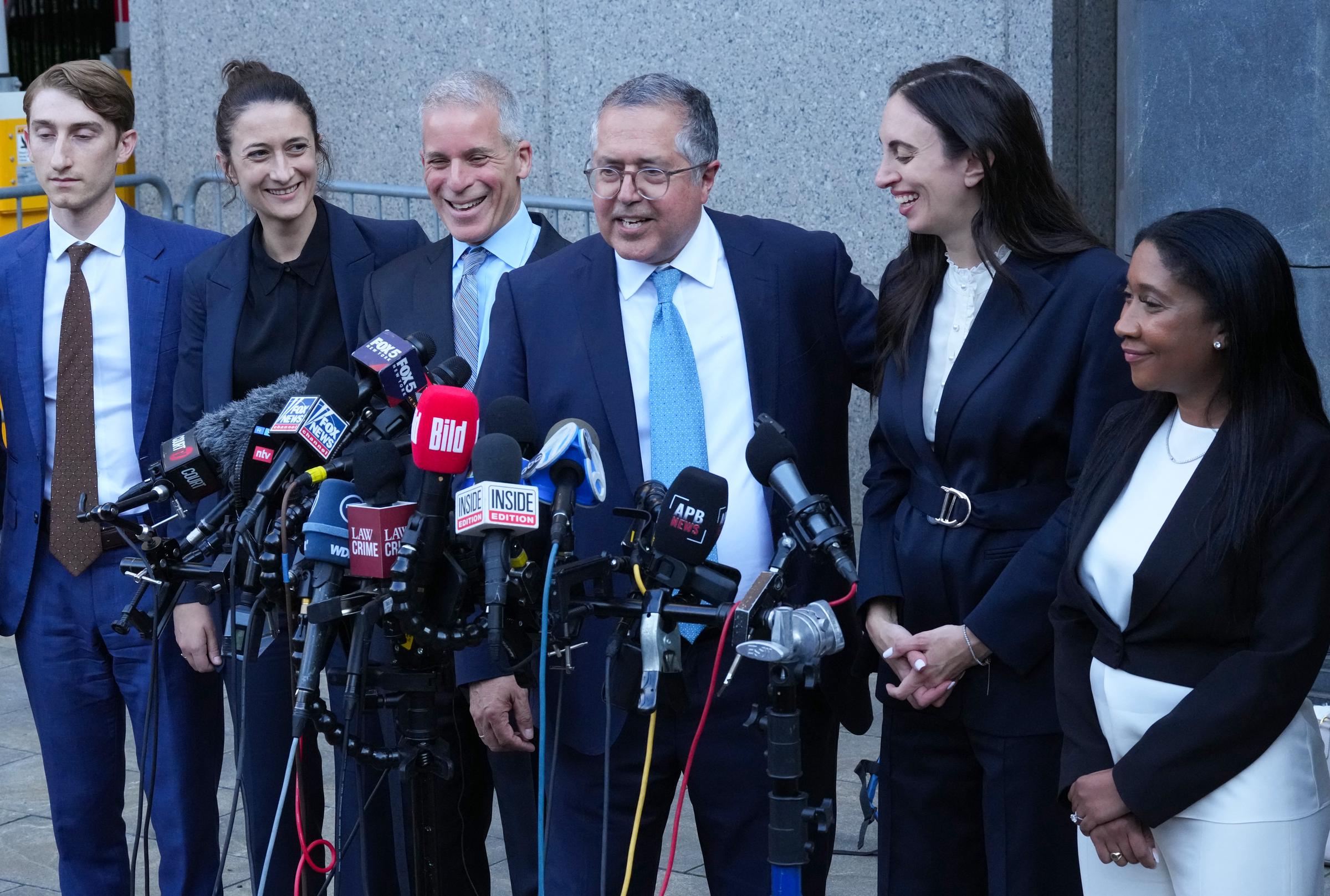 Marc Agnifilo and members of Sean "Diddy" Combs' legal team smile and laugh as they face reporters outside Manhattan Federal Court on July 2, 2025. The mood is visibly upbeat after the partial verdict.