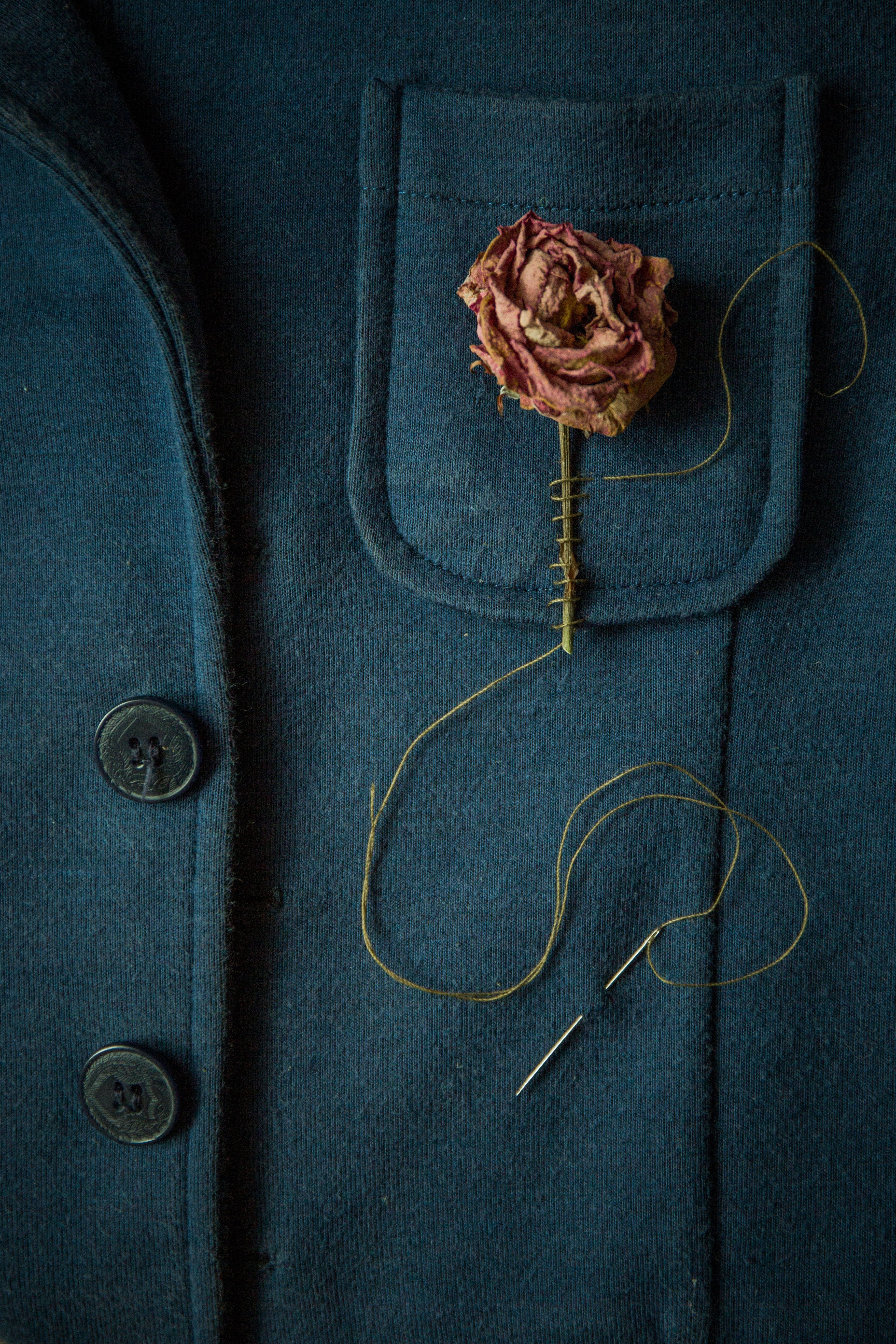 Rosa seca cosida al bolsillo de una chaqueta. | Foto: Pexels