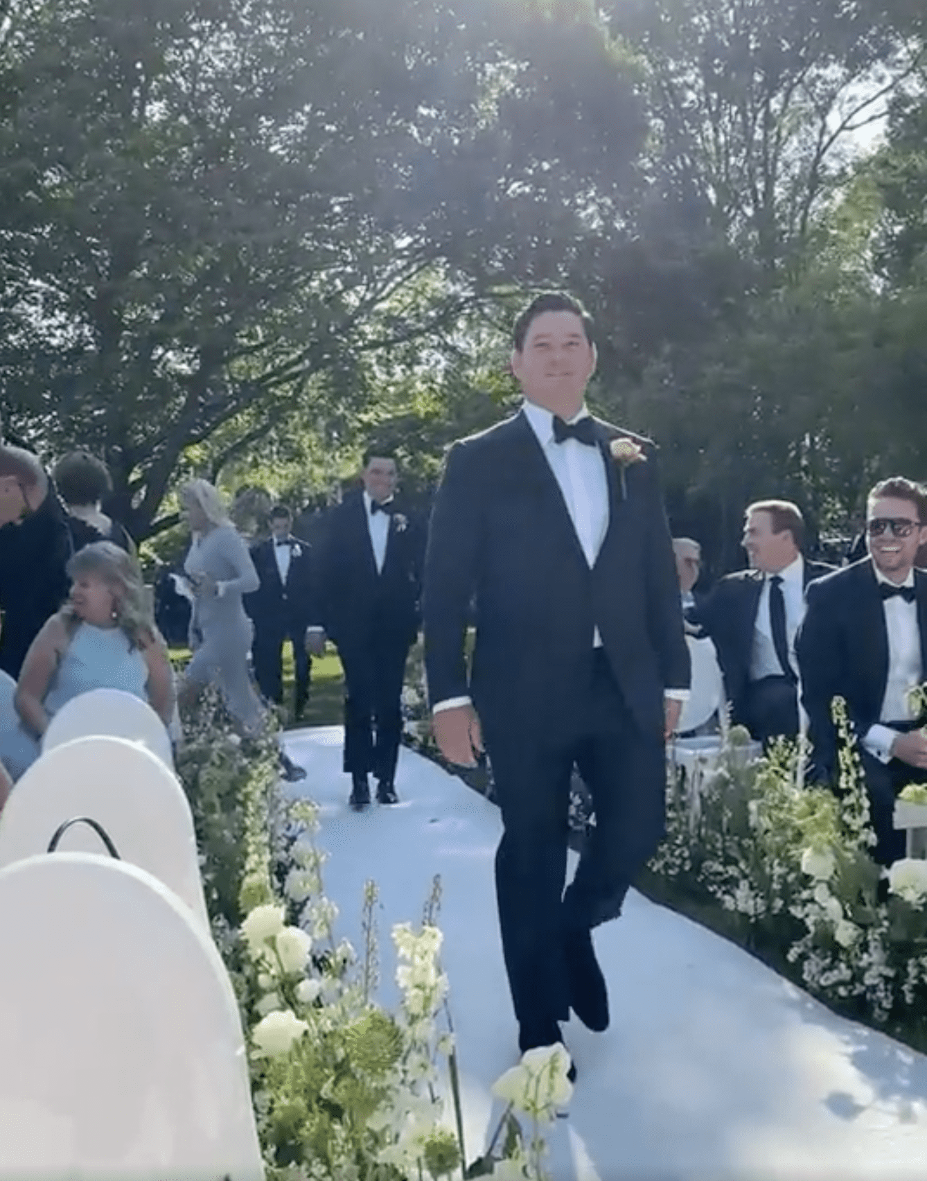 The groom walks down the aisle with the lady in cream-colored dress pictured in the background. | Source: reddit.com/r/weddingshaming