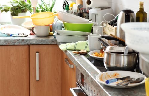 Kitchen counter piled with dirty dishes. | Source: Shutterstock.