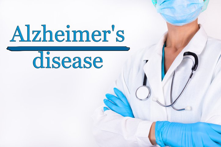 The inscription Alzheimers disease on a white background and a doctor with a stethoscope | Photo: Getty Images