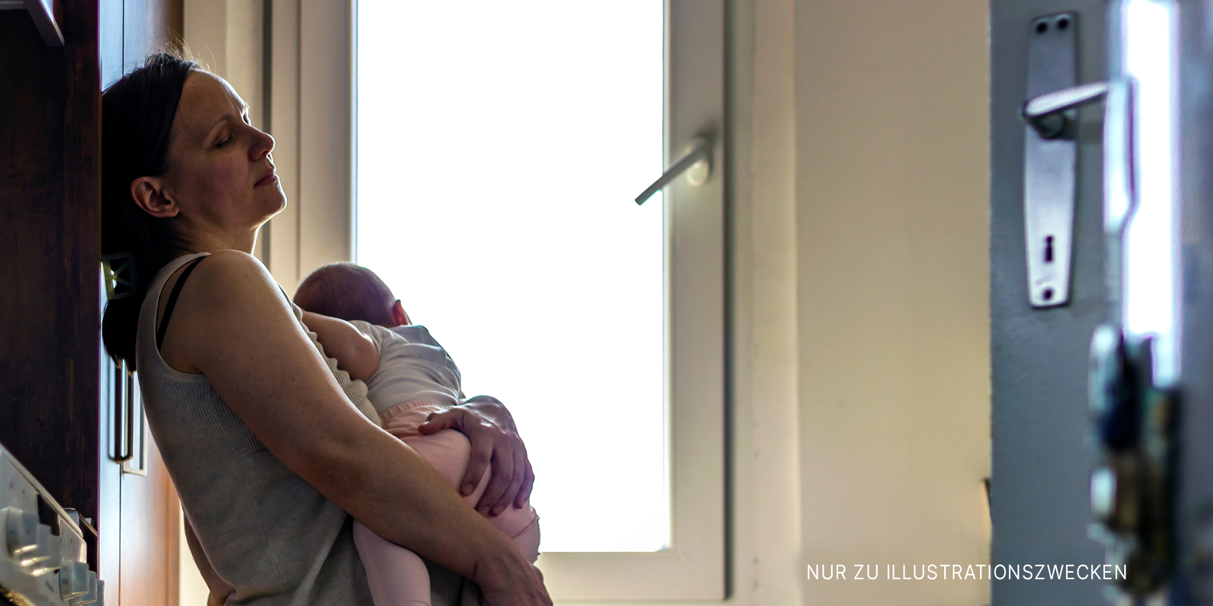 Frau hält ein schlafendes Baby | Quelle: Shutterstock