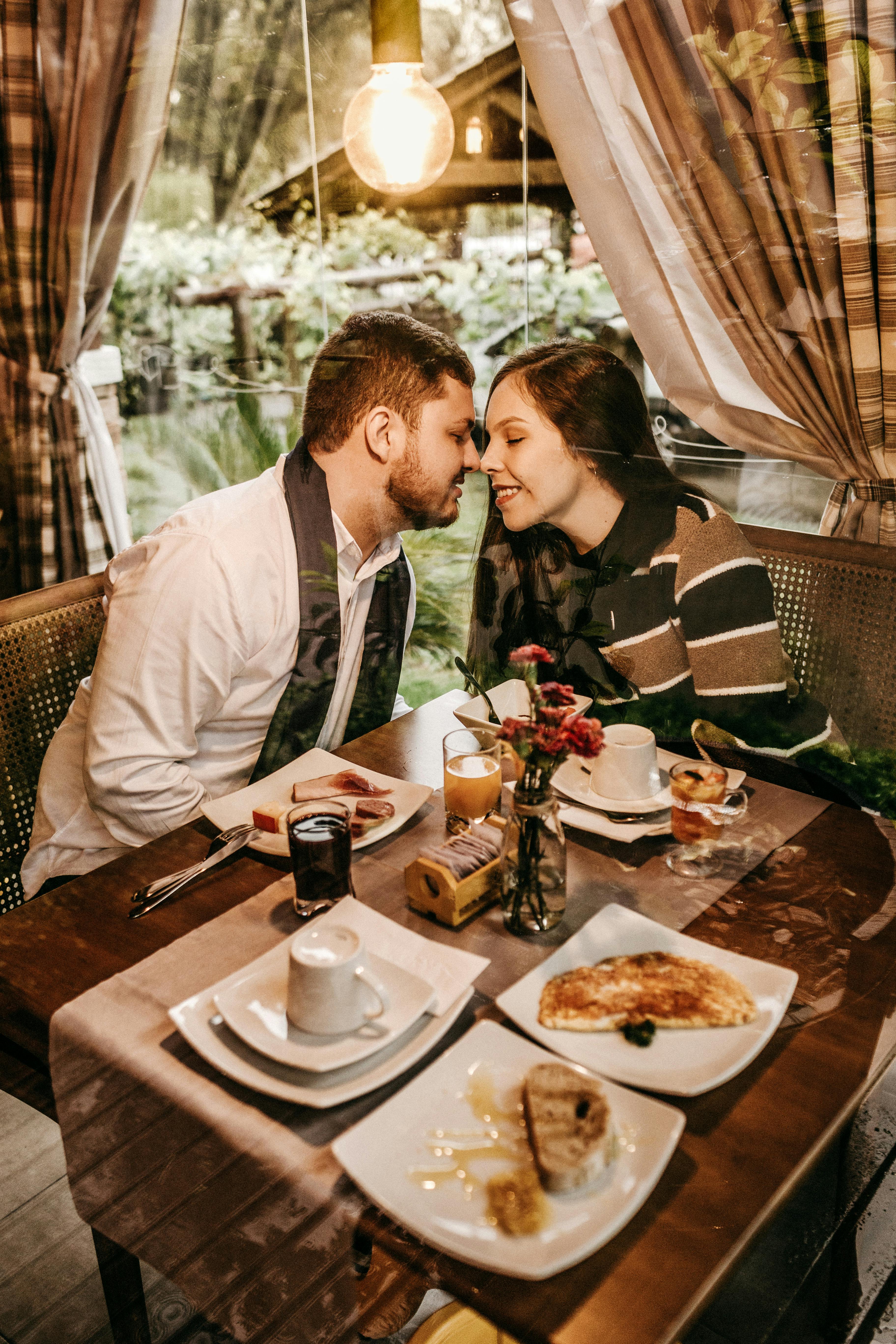 A couple about to kiss at a restaurant | Source: Pexels