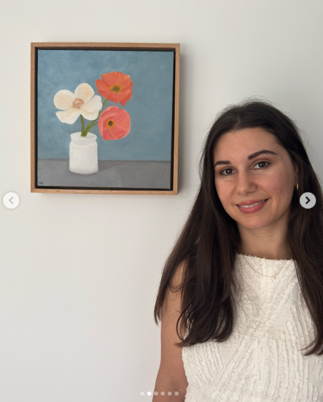 Kristy Adler posing next to one of her paintings in a post dated April 27, 2025 | Source: Instagram/kristyadlerart