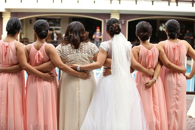 Bride with bridesmaids in pink at a wedding | Photo: Pixabay
