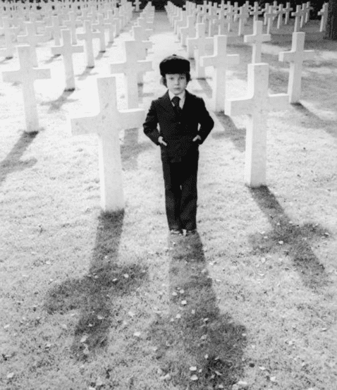 Harvey Stephens stands in a cemetery of cross-shaped tombstones in a promotional still from the 1976 film, "The Omen." | Photo: Getty Images