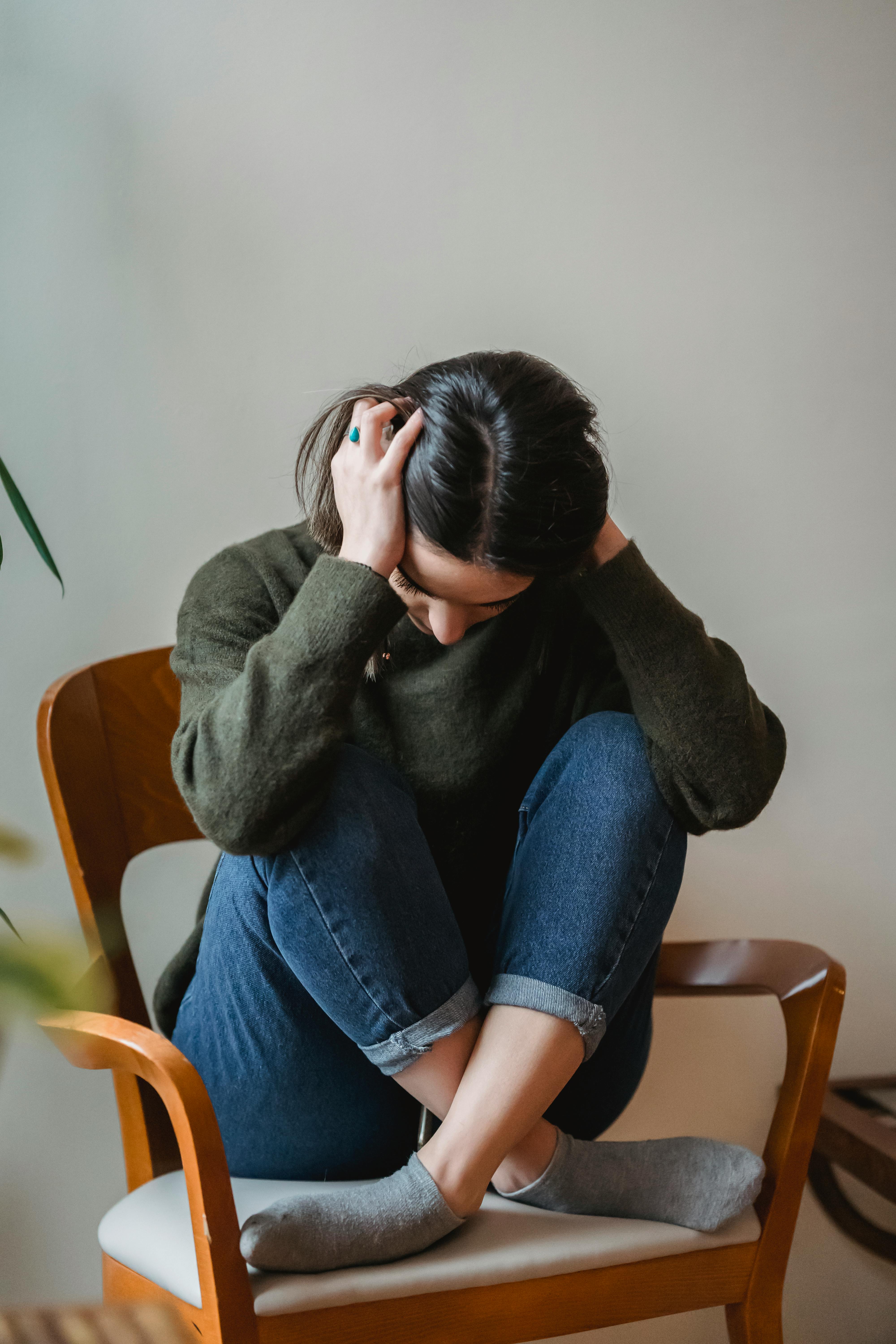An upset young woman holding her head in her hands | Source: Pexels