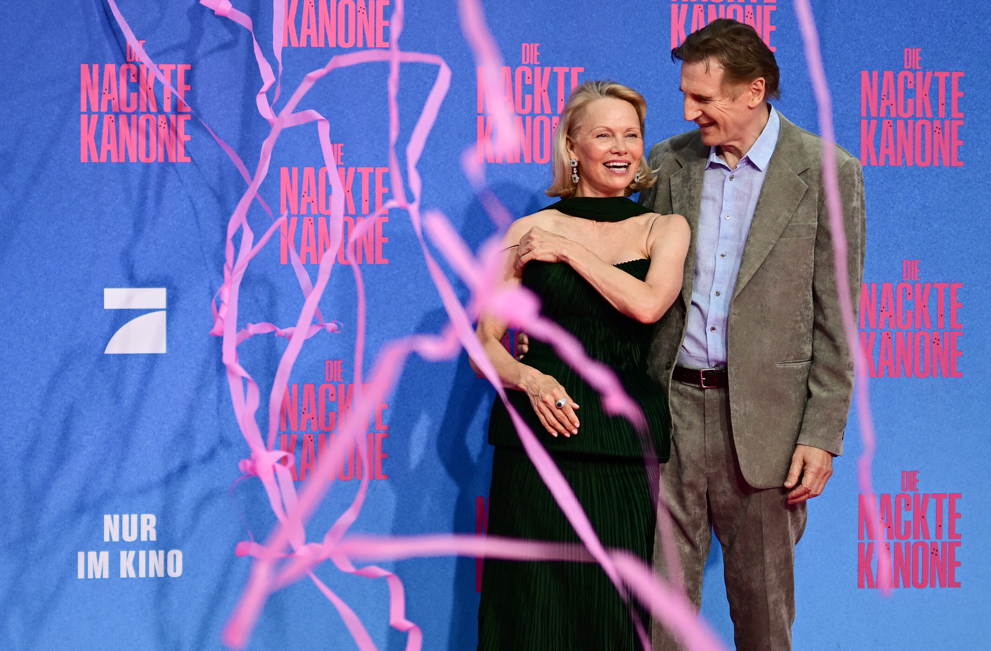 Liam Neeson and Pamela Anderson pose on the red carpet upon arrival for the German Premier of “The Naked Gun" in Berlin, on July 24, 2025. | Source: Getty Images