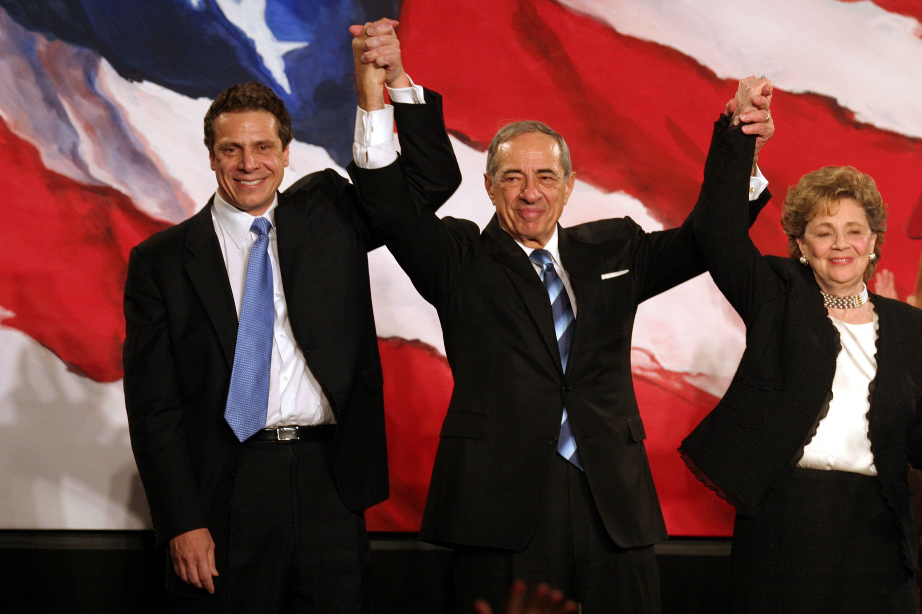 Andrew Cuomo, Mario Cuomo and Matilda Cuomo raise their hands in celebration during the Democratic Victory Celebration 2006| Photo: Getty Images