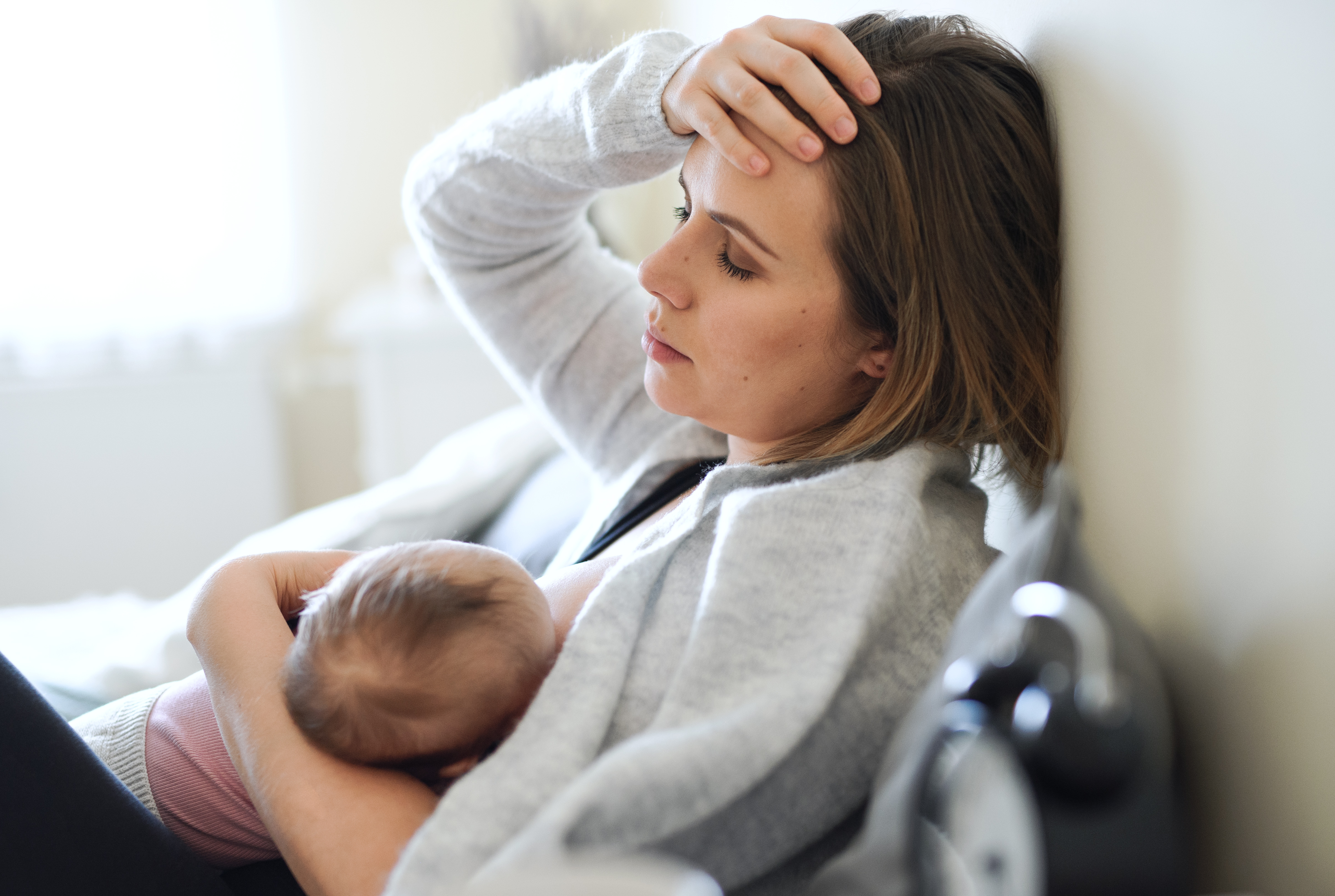 An exhausted woman holding a baby | Source: Getty Images