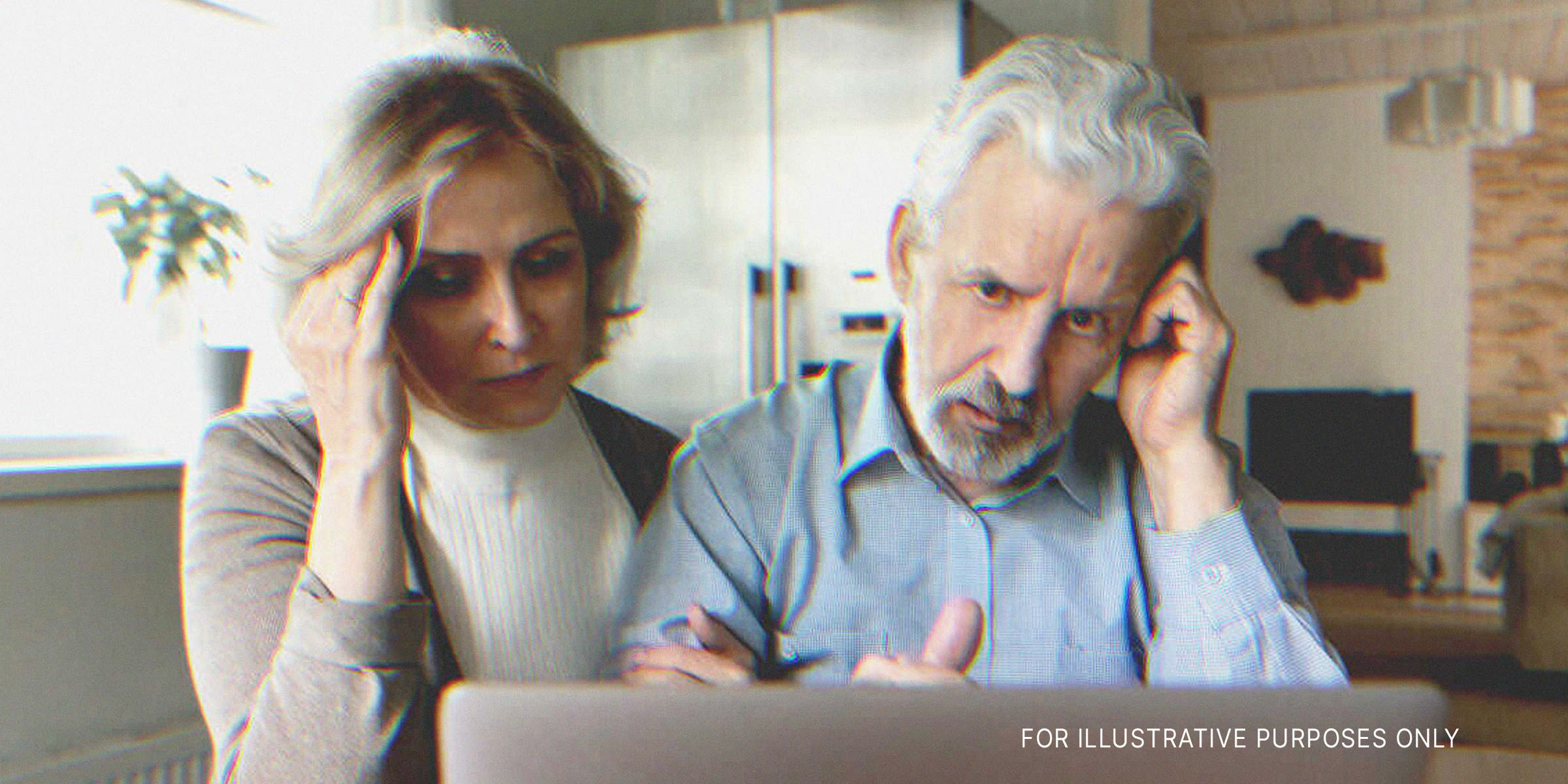An older couple is pictured looking upset while staring at a laptop | Source: Shutterstock