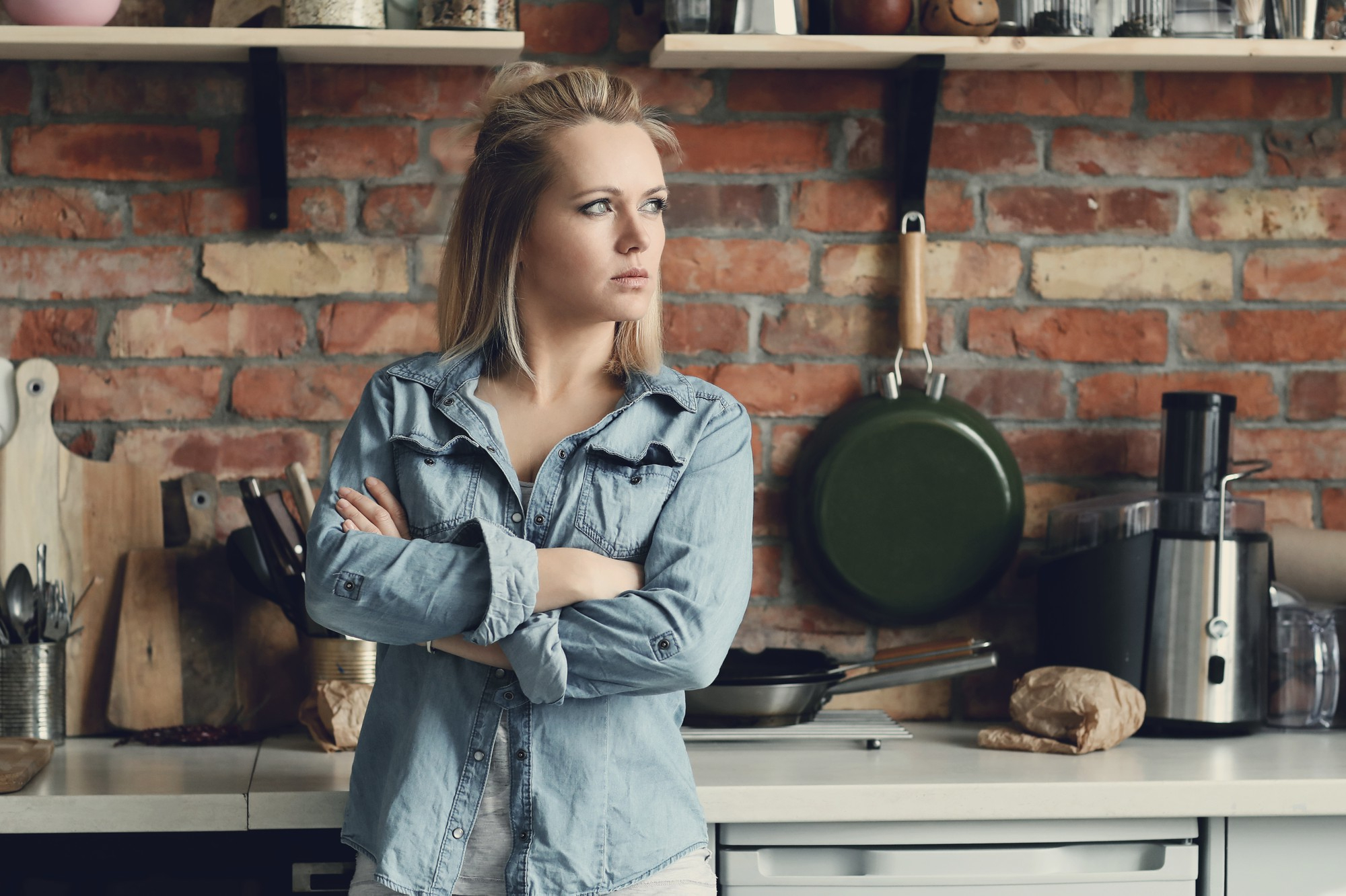 A woman listening to something while in the kitchen | Source: Freepik