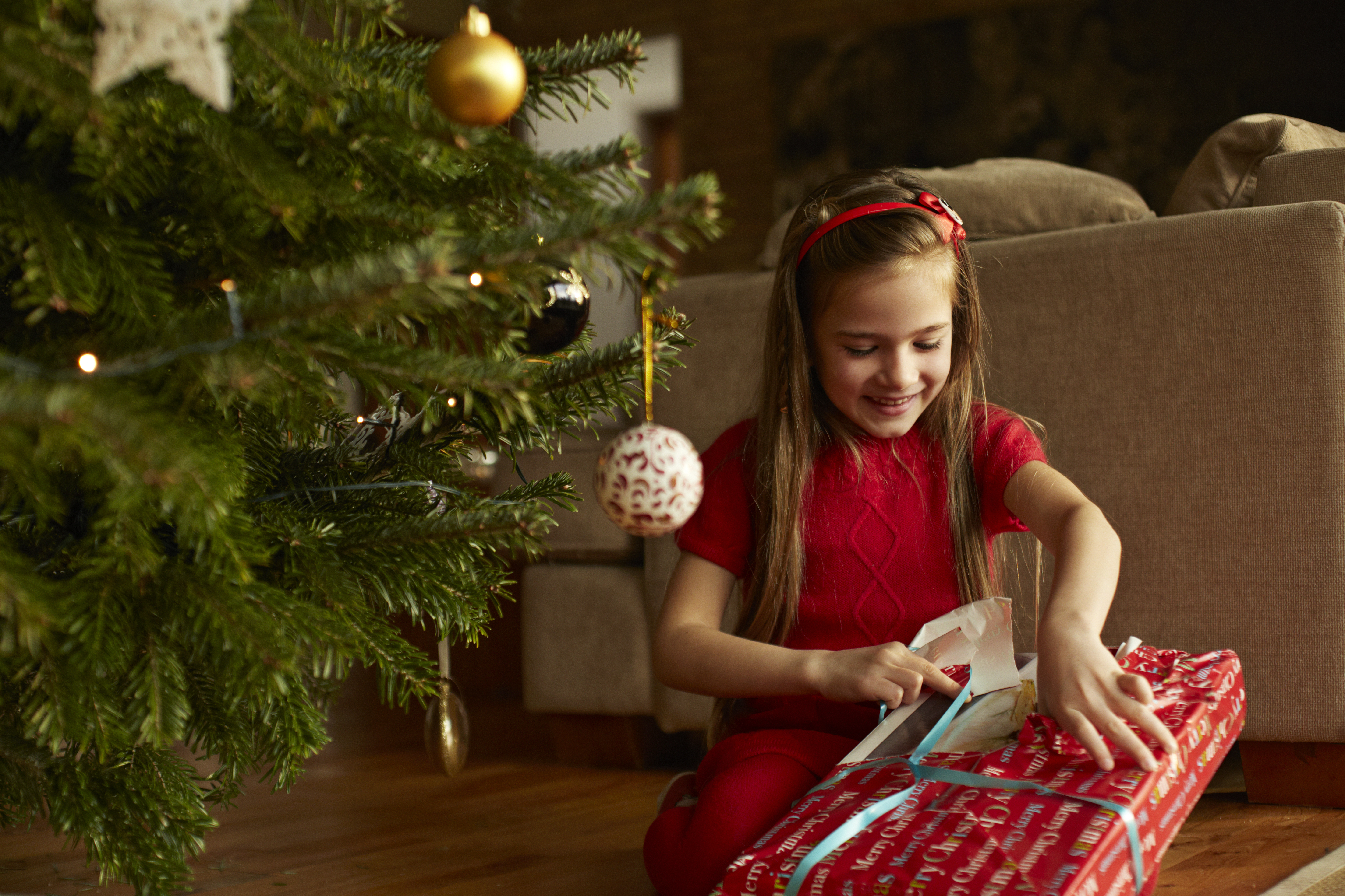 Little girl opening a Christmas present | Source: Getty Images