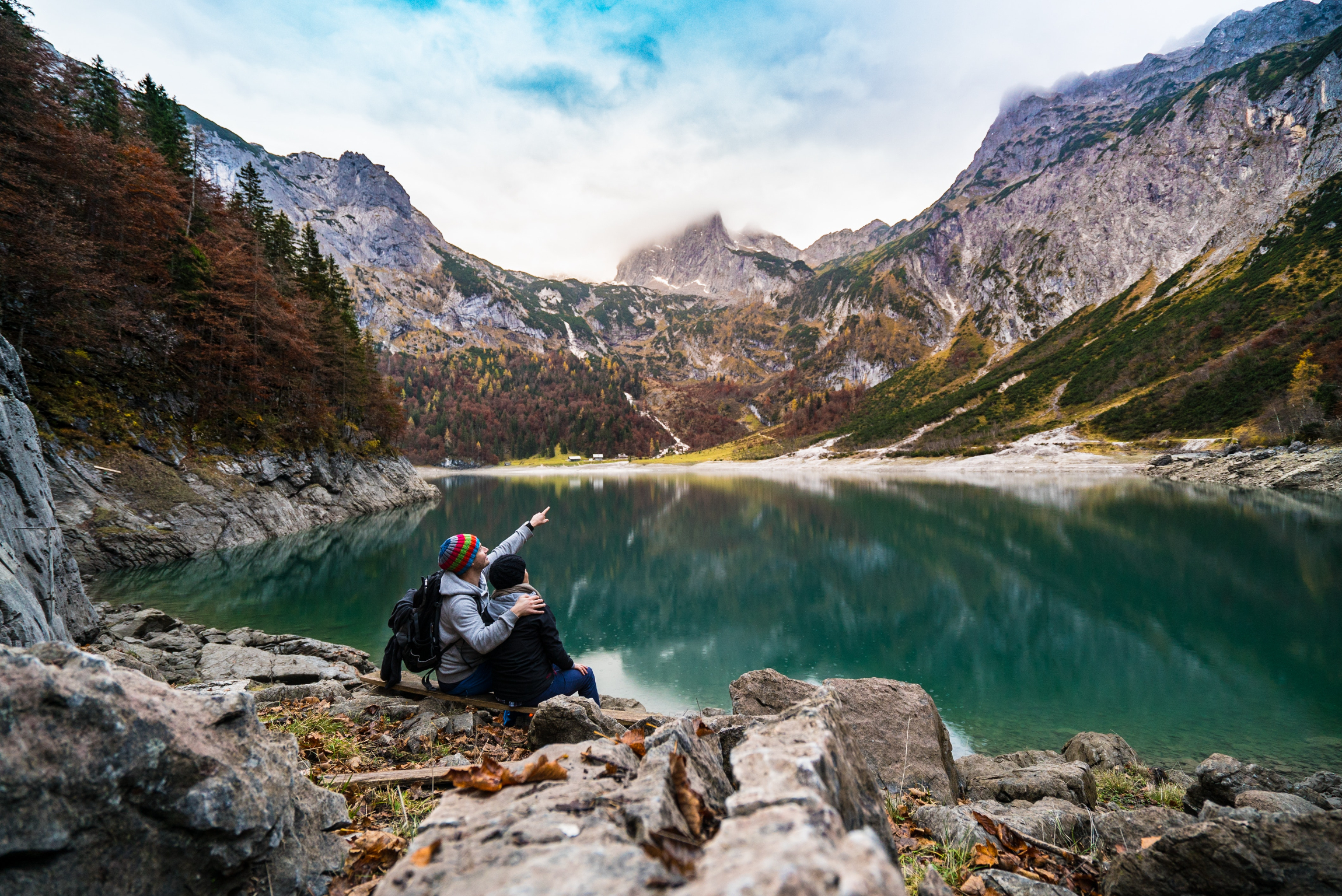 A couple sitting beside a lake. | Source: Pexels