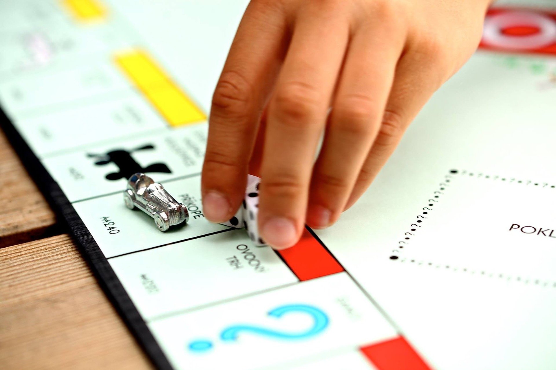 Mano sujetando los dados del juego de mesa Monopolio. | Foto: Pixabay