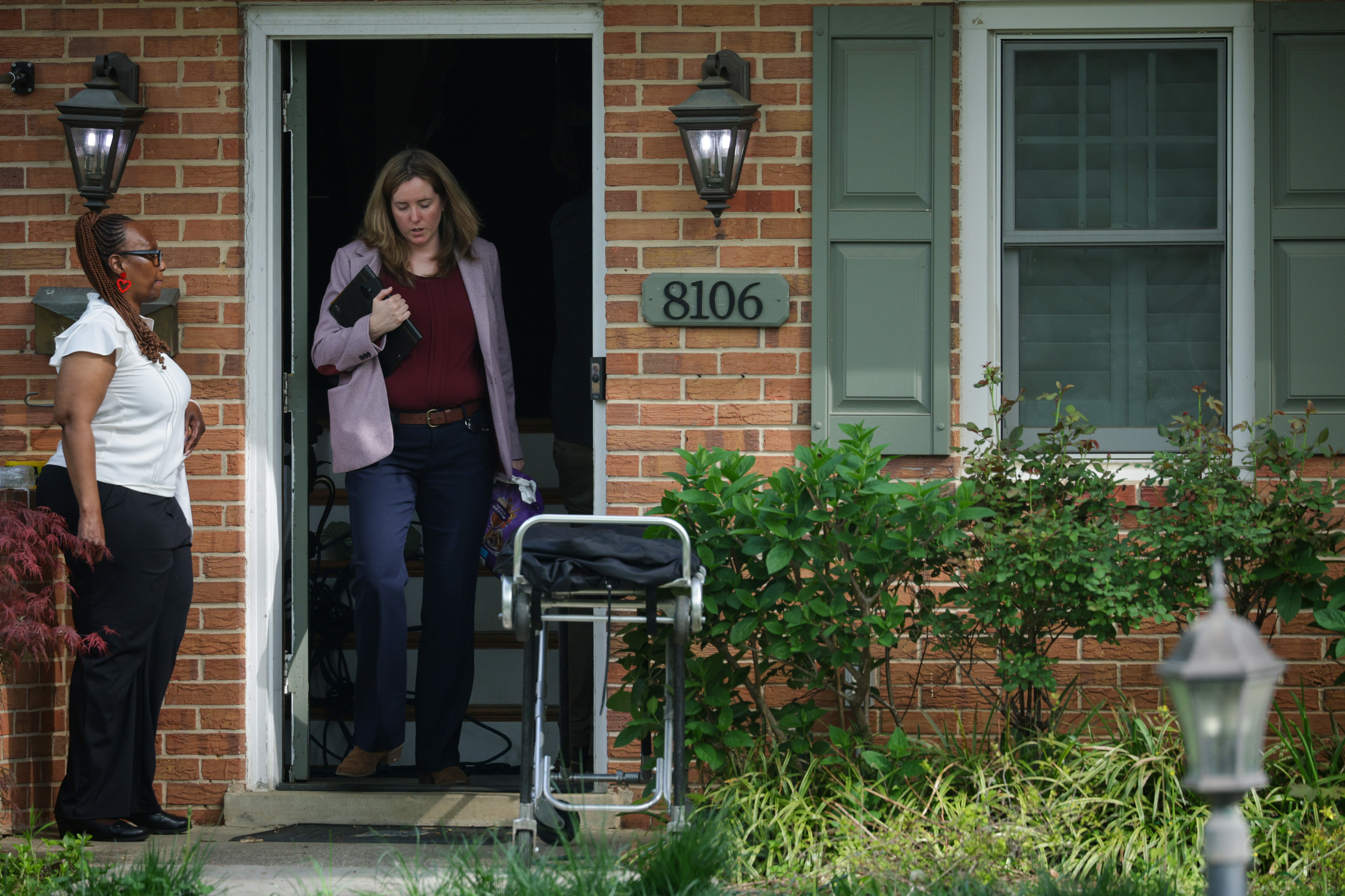 An investigator steps out of the Fairfax home carrying equipment while another stands at the entrance in Annandale, Virginia on April 16, 2026 | Source: Getty Images