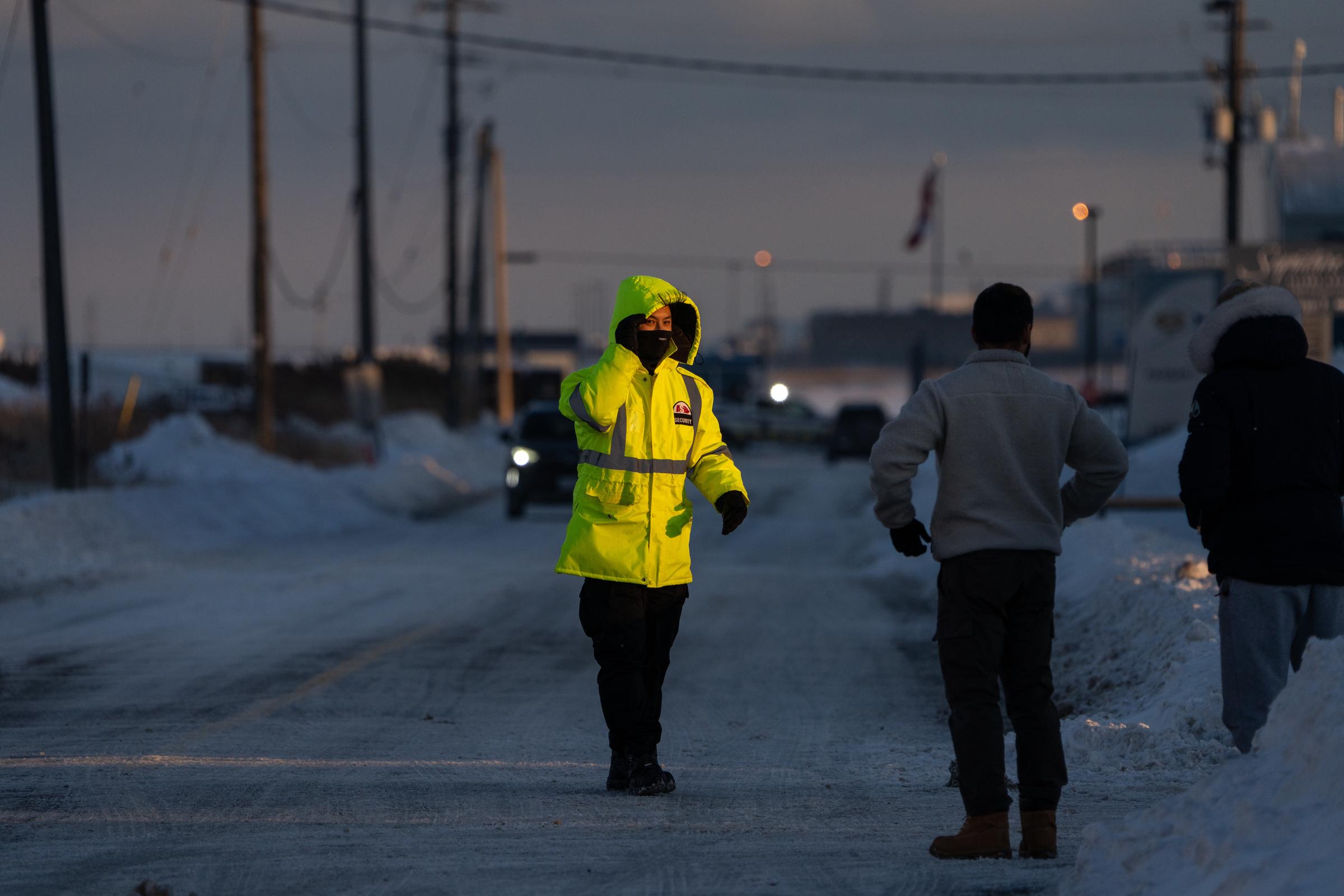 An airport employee directs traffic near the site of a Delta Airlines plane crash at Toronto Pearson International Airport | Source: Getty Images