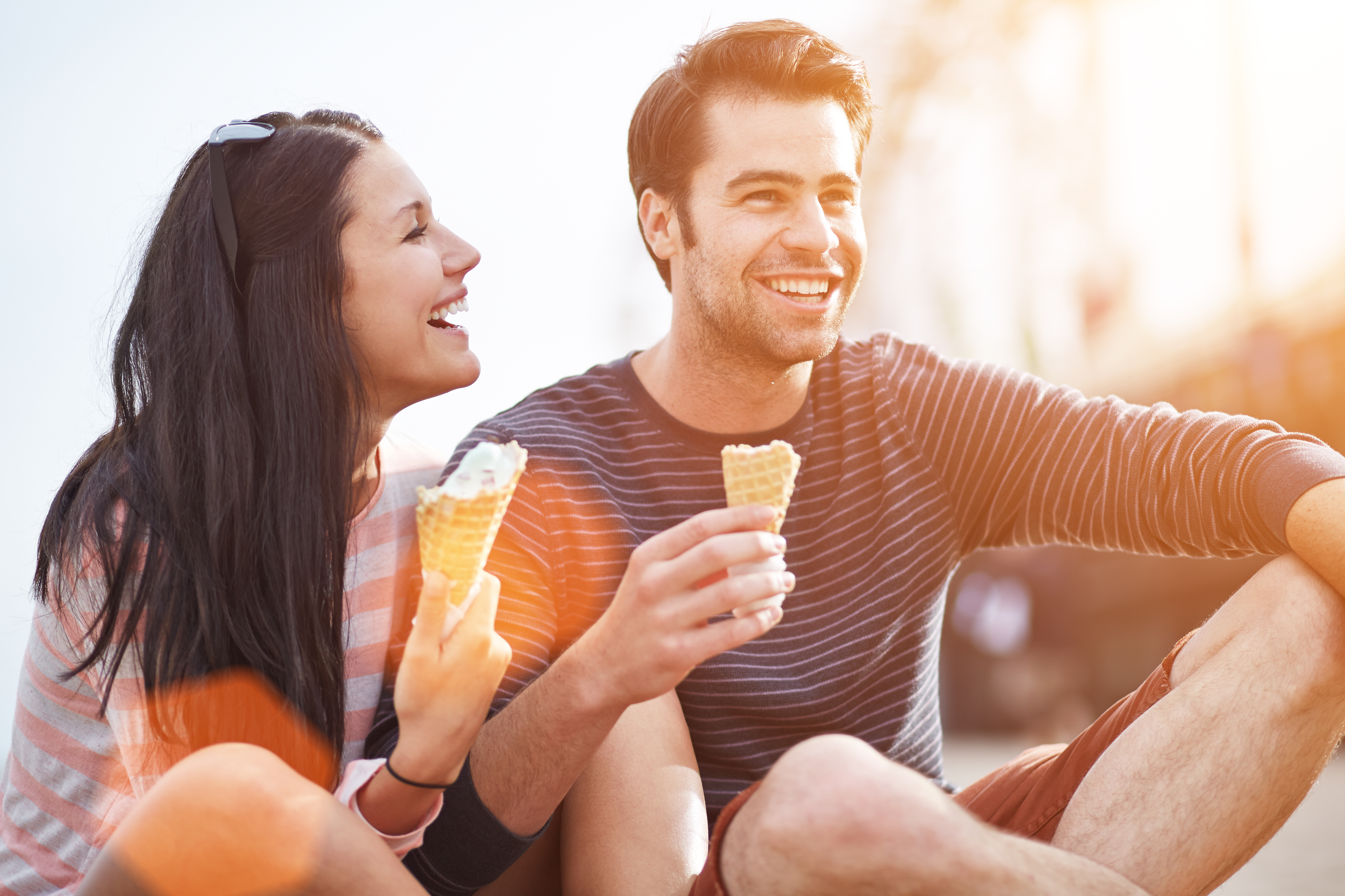 A man and woman laughing while eating ice-cream | Source: Shutterstock
