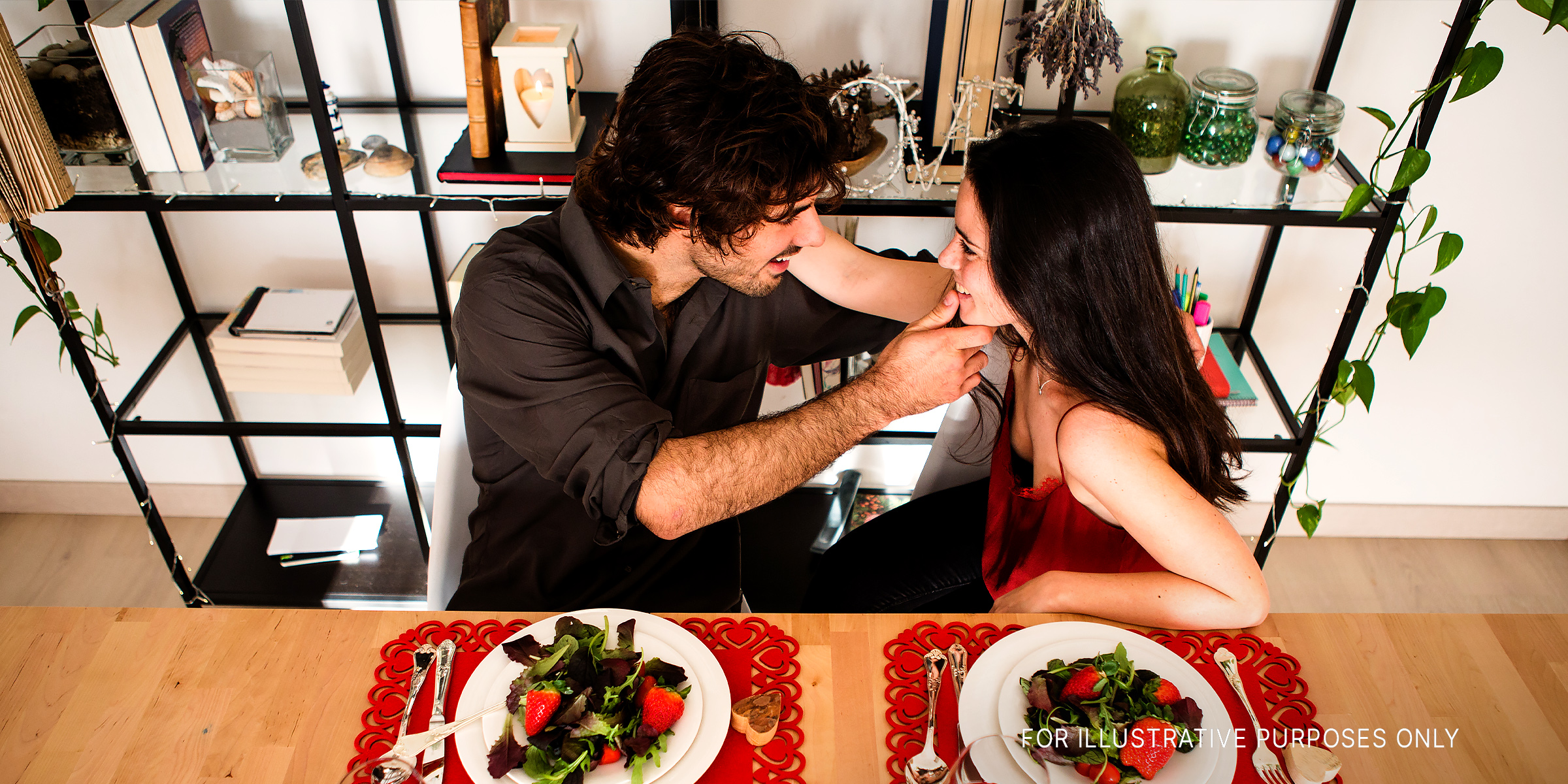 A couple touching while having a romantic dinner | Source: Flickr.com