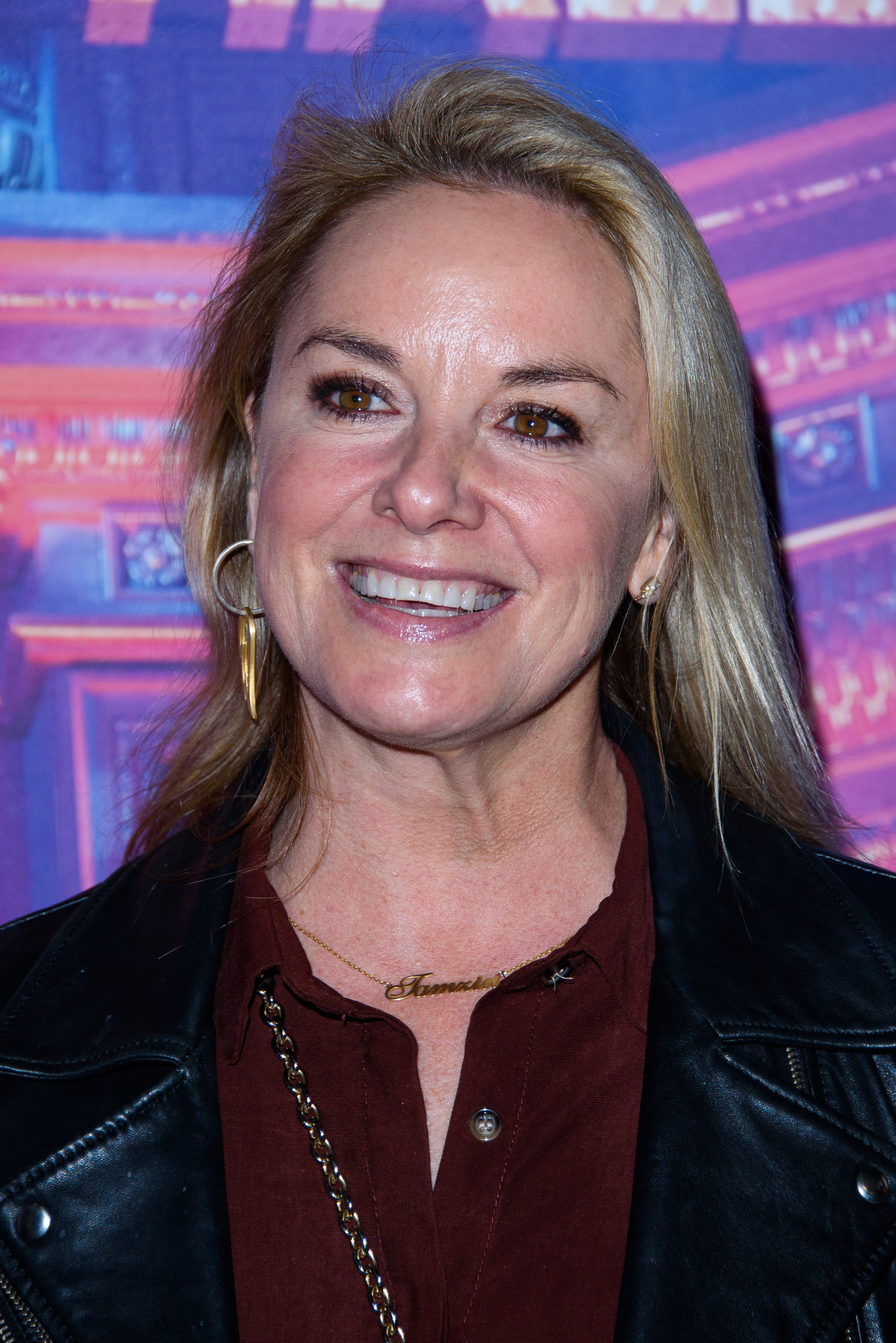 Tamzin Outhwaite was photographed attending Emma Bunton's Christmas party in London on December 6, 2019, smiling broadly as she arrived at the festive gathering. Wearing a leather jacket over a deep-toned blouse and minimal jewellery, the actress looked at ease in a more relaxed, off-duty setting, offering a glimpse of her natural complexion and features.