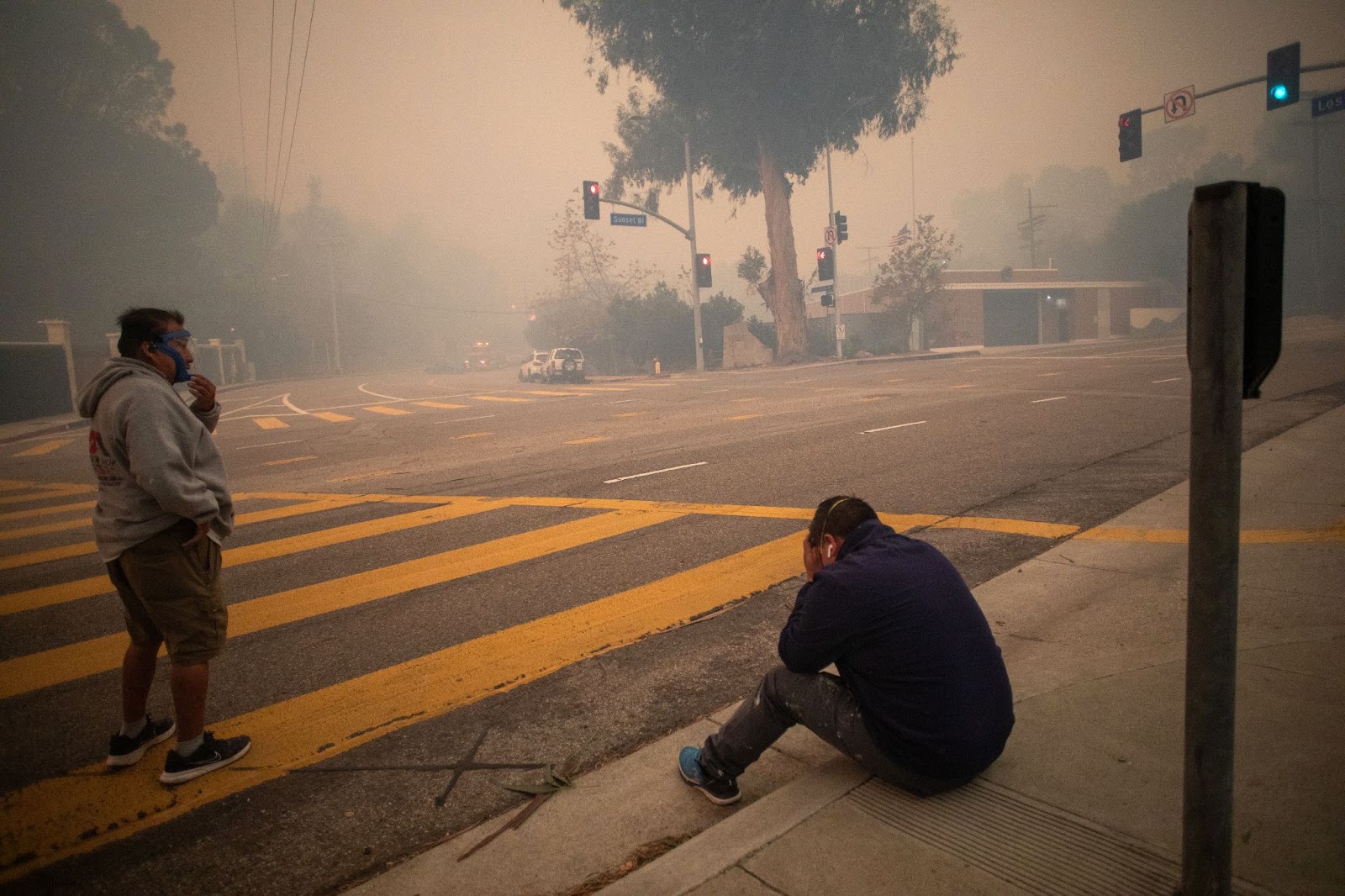 People stopping to take a breath as they evacuate along Sunset Boulevard during the Palisades fire on January 7, 2025. | Source: Getty Images