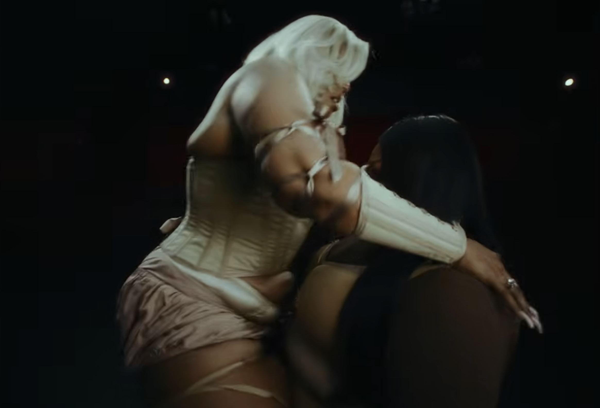 A sudden embrace interrupts the stillness between them | Source: YouTube/Lizzo