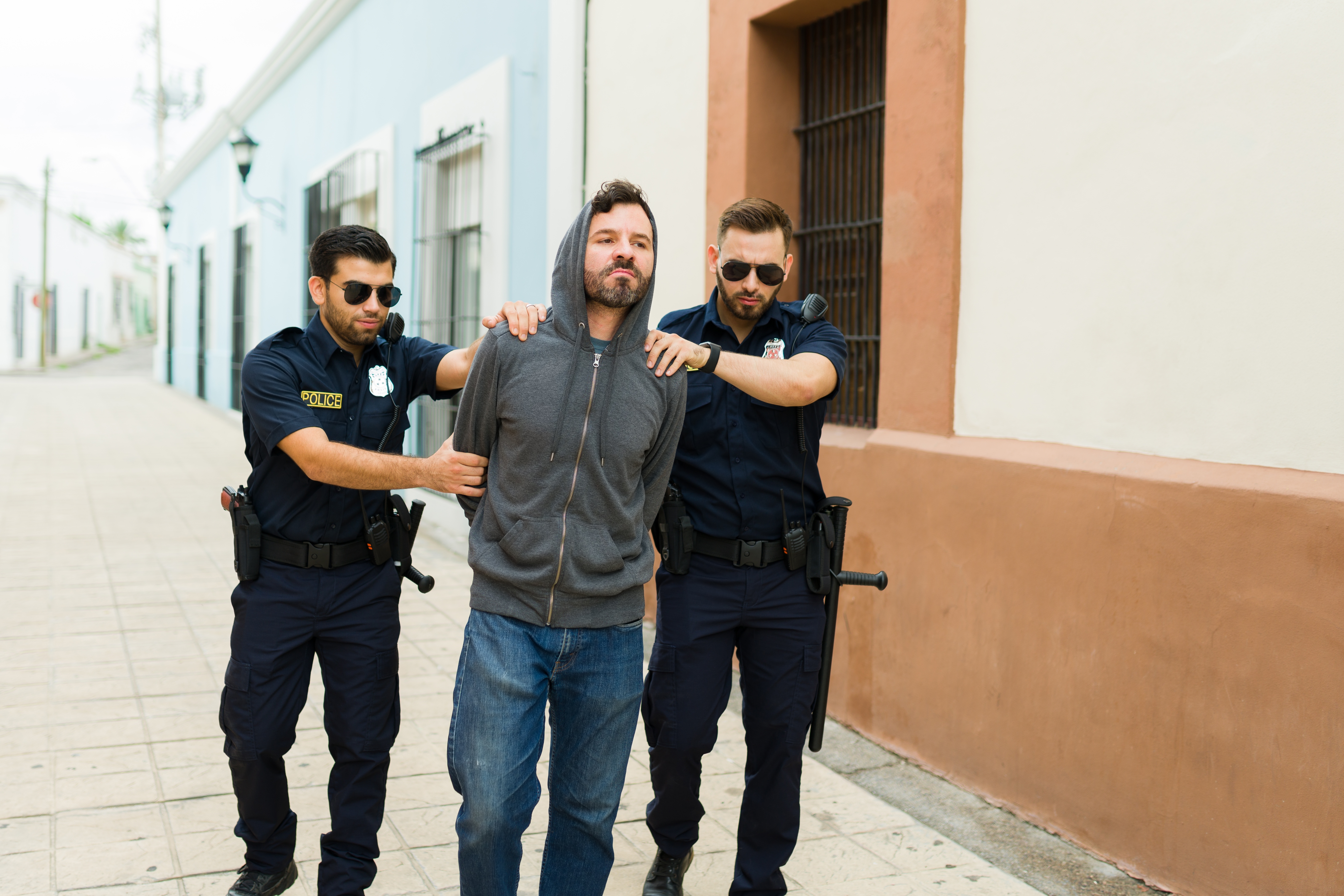 Violent criminal with a hoodie getting arrested by the police | Source: Shutterstock.com