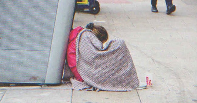 Una joven sin hogar sentada en el suelo | Shutterstock