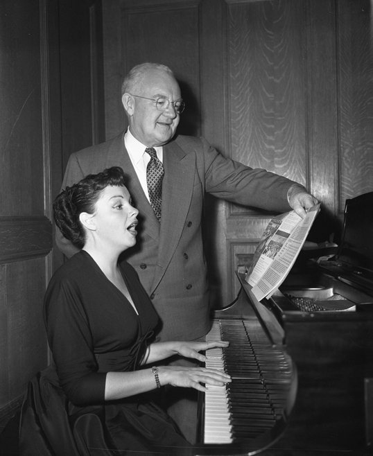 Judy Garland at the piano with Los Angeles Mayor Fletcher Bowron advertising the Music Week | Source: Wikimedia Commons