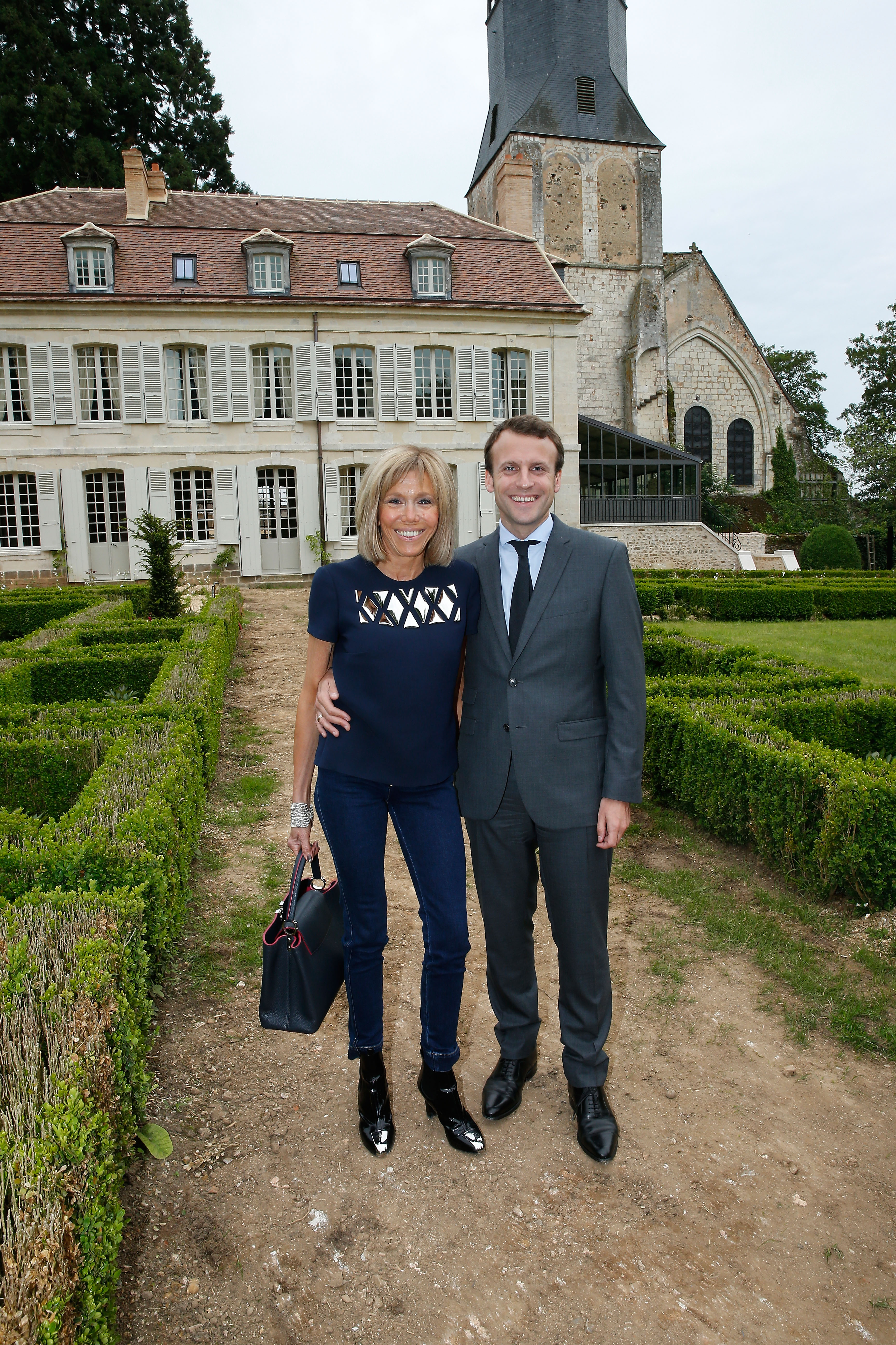 Brigitte and Emmanuel Macron posed outside the College Royal et Militaire de Thiron-Gardais during the inauguration of its exhibition rooms on June 10, 2016, blending their public appearances with shared support for French heritage and education.
