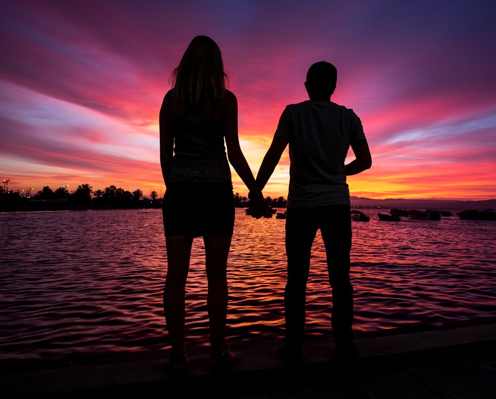 A silhouette of a couple consisting of a tall girl and a short boy. | Photo: Shutterstock