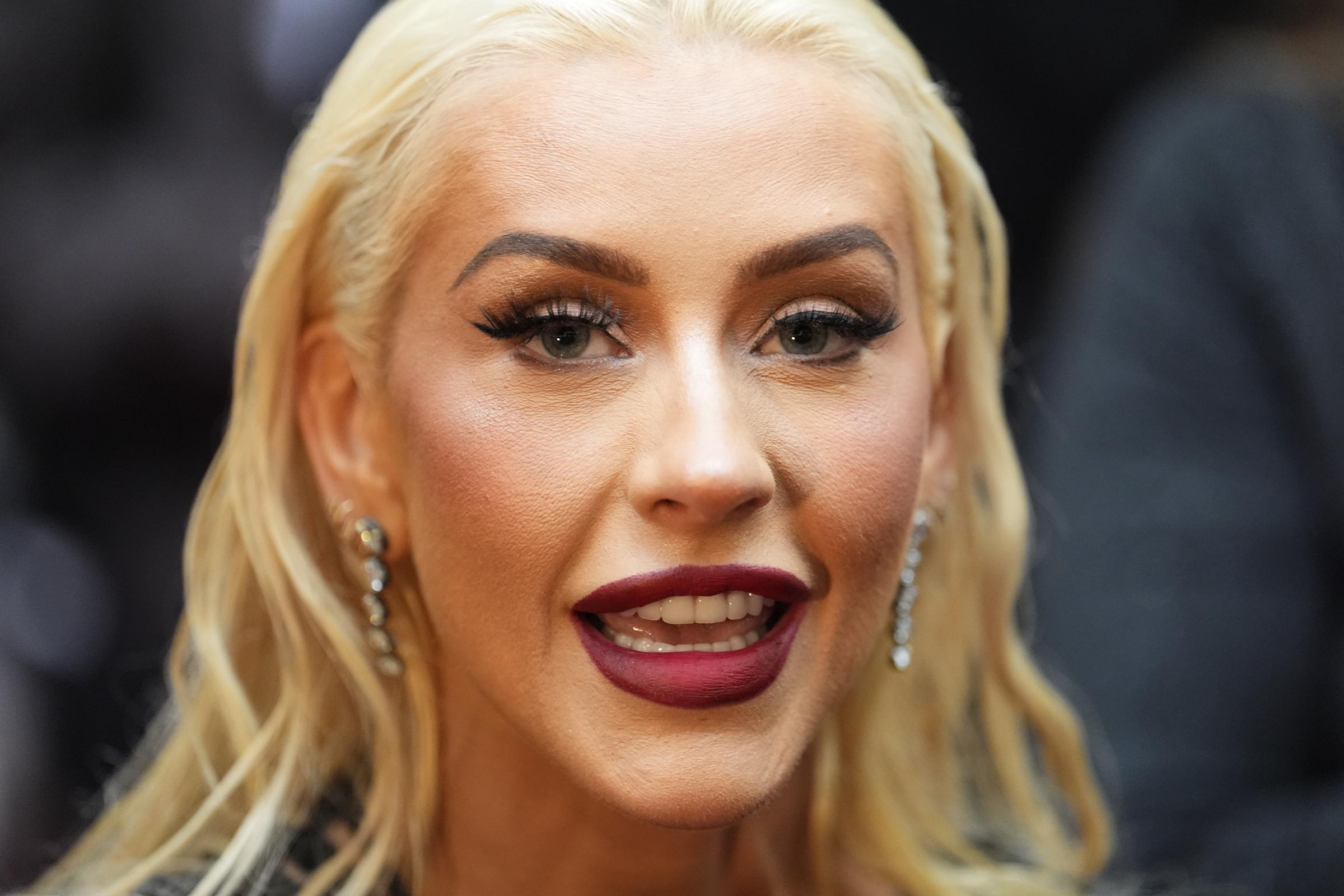 A decade later, Aguilera embraced a softer Hollywood-inspired look with voluminous blonde curls and classic red lipstick. Around this period, public attention began shifting from her fashion choices to discussions about changes in her appearance. | Source: Getty Images